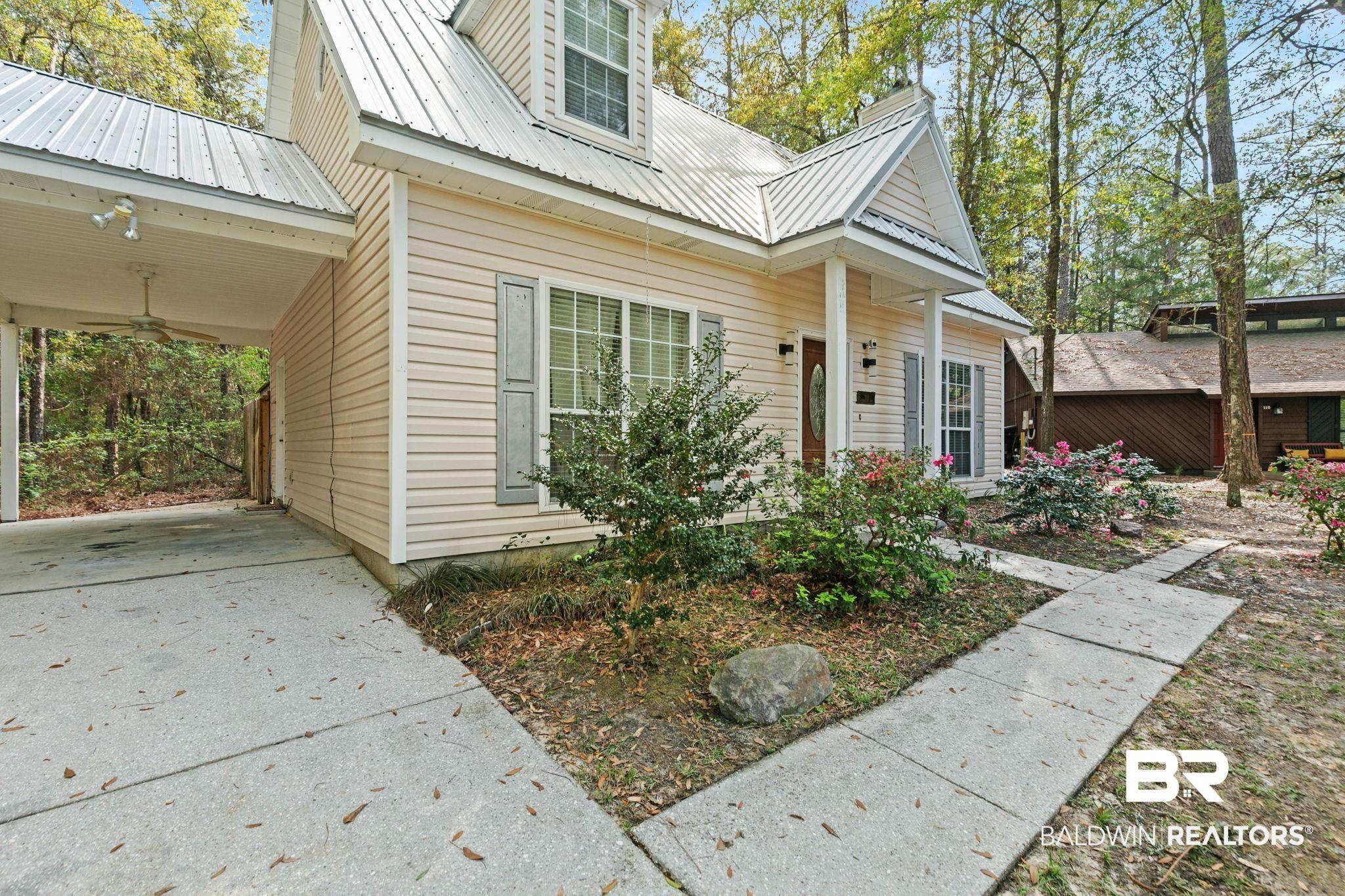 Image 3: Property entrance with driveway, a carport, a ceiling fan, and a metal roof