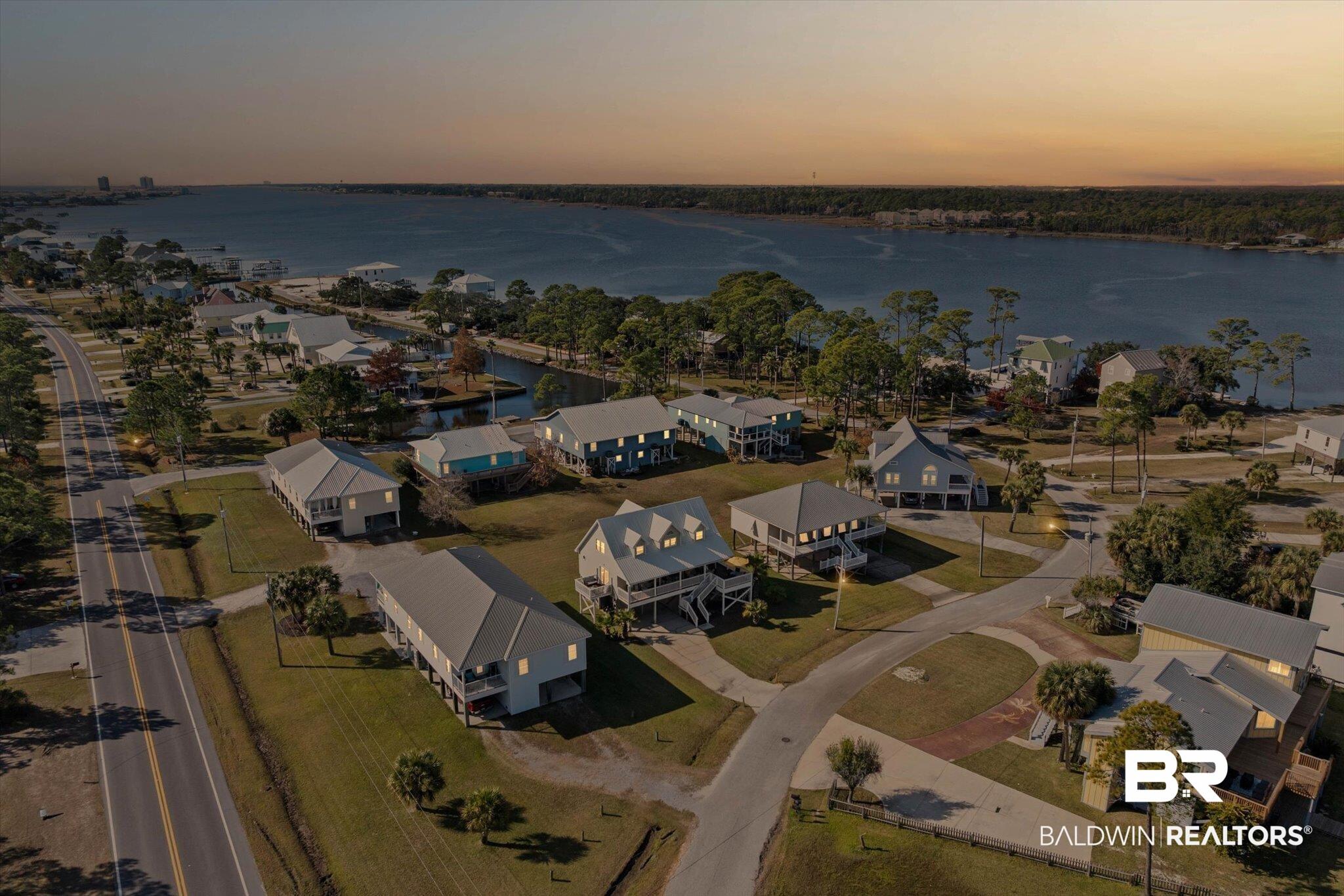 Image 2: Aerial view of property's location with a large body of water and nearby suburban area