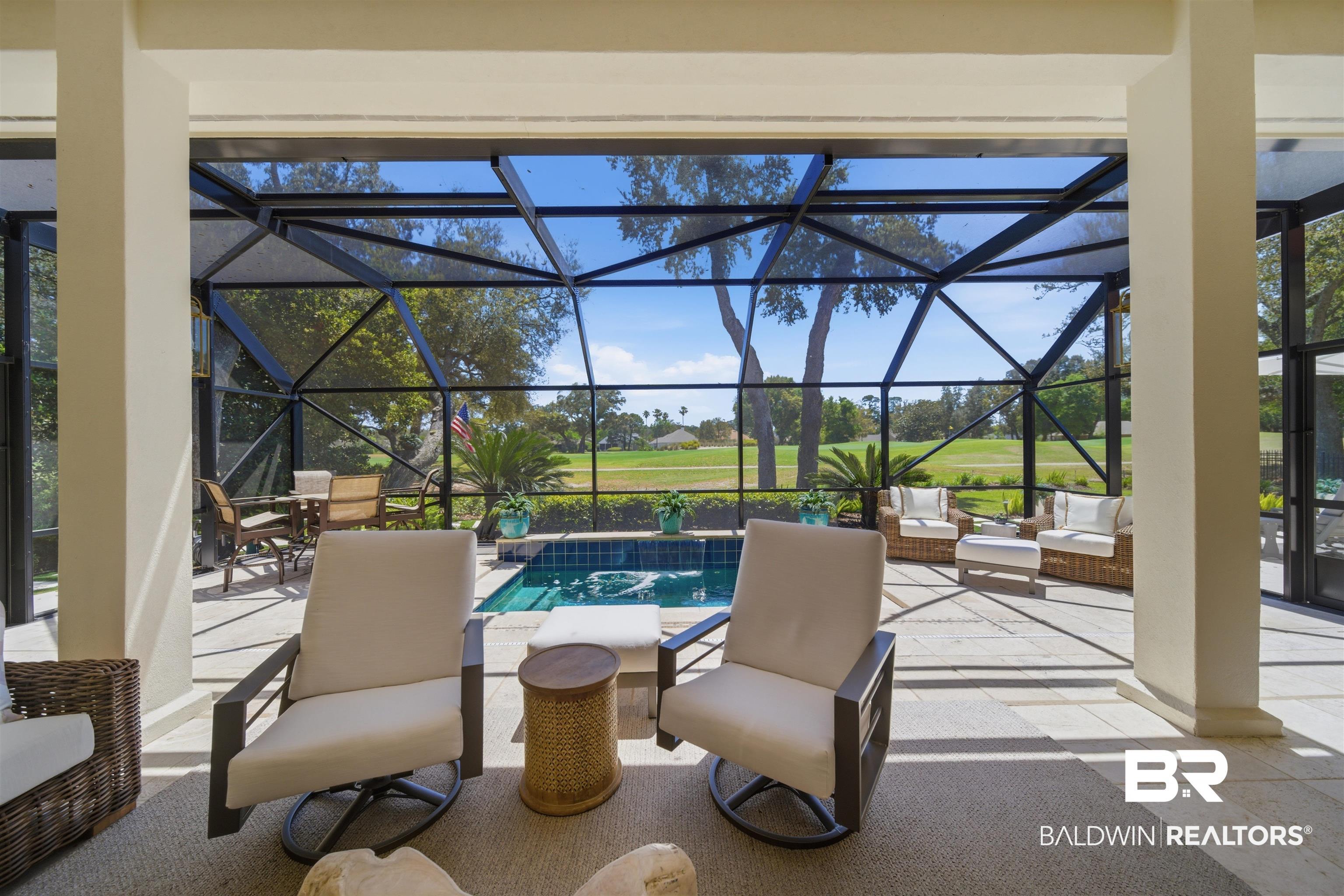Image 3: Screened lanai featuring a swimming pool, integrated spa, and extensive patio area with light-toned pavers