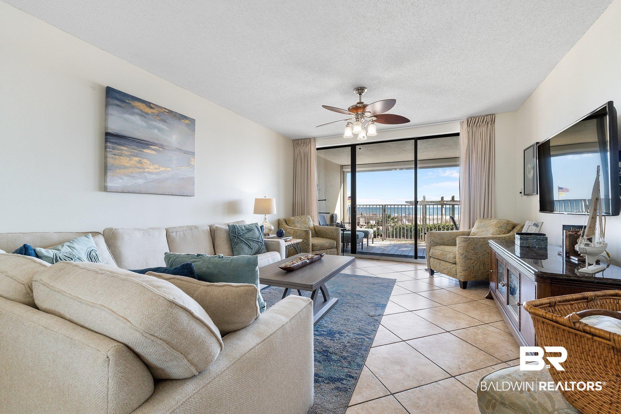 Image 4: Living area featuring floor to ceiling windows, a textured ceiling, ceiling fan, and light tile patterned floors