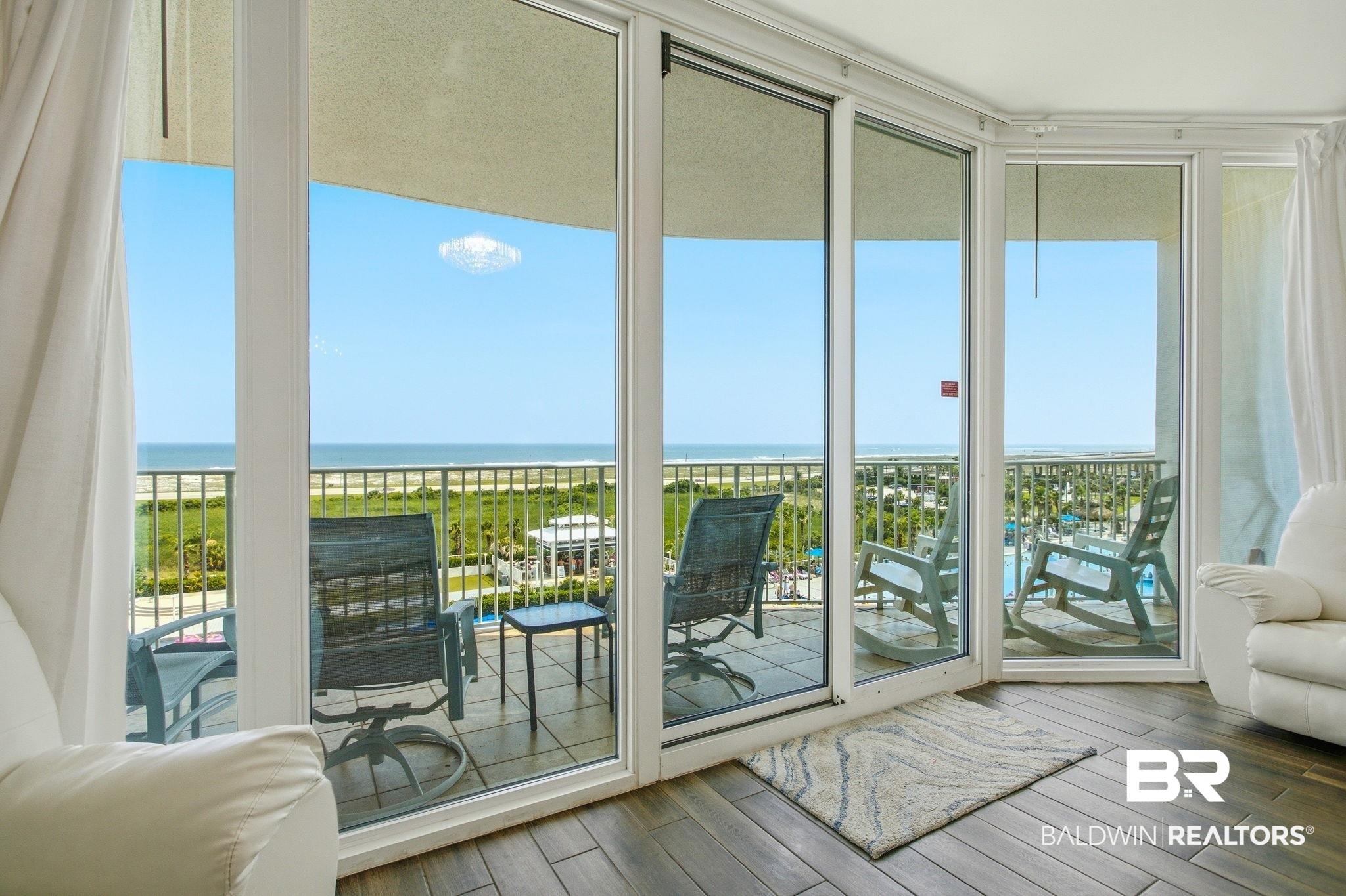 Image 4: Expansive sliding glass doors open to a private balcony with water frontage