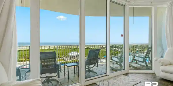 Image 4: Expansive sliding glass doors open to a private balcony with water frontage