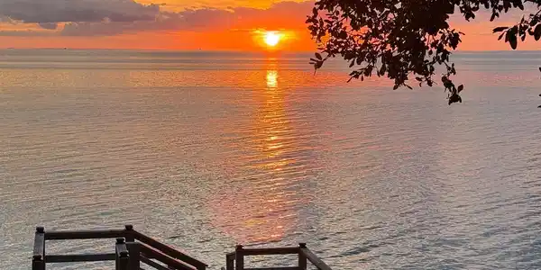 Image 2: Waterfront property featuring a private dock with wooden railings and steps, offering direct access to the water