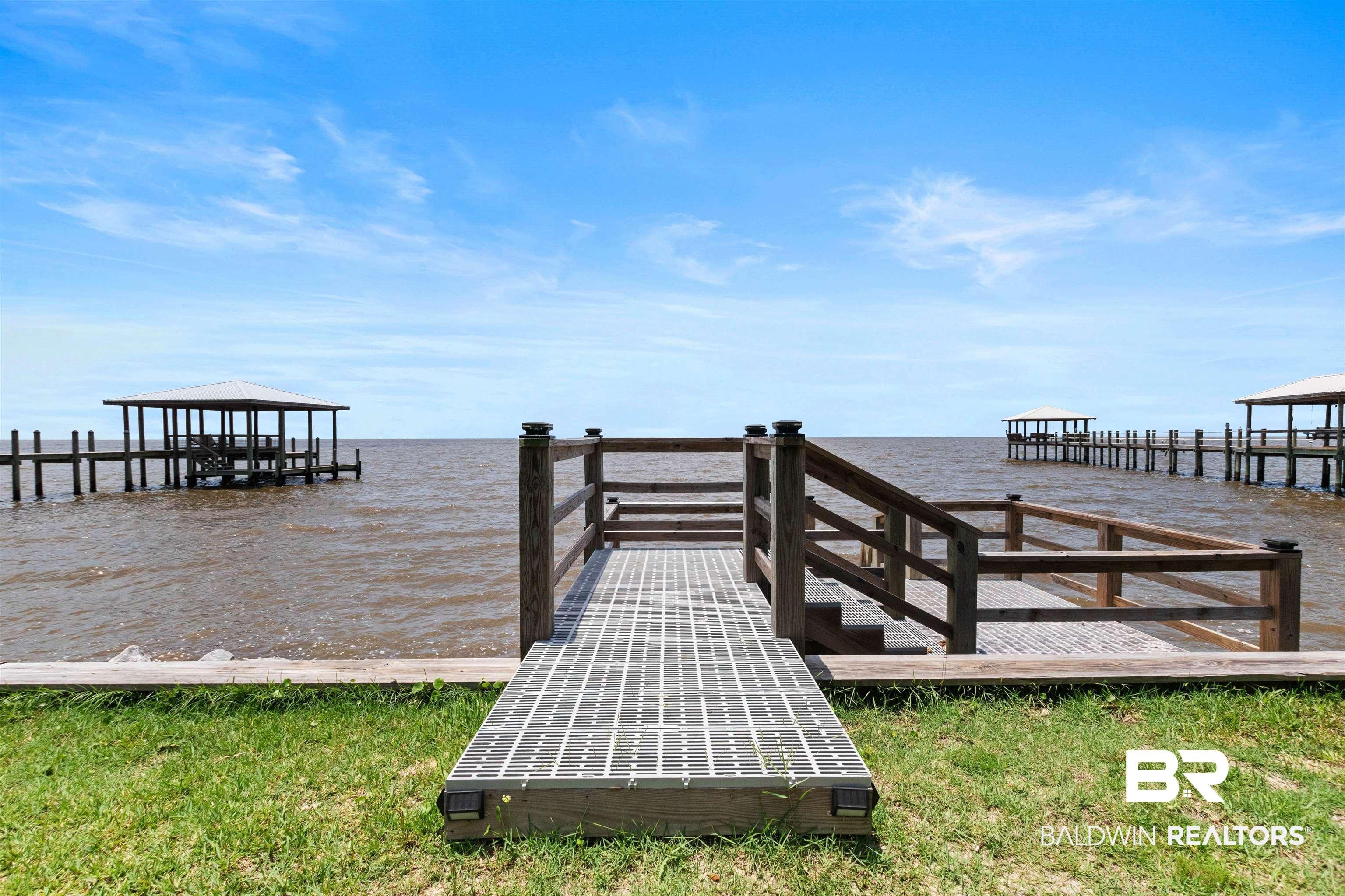 Image 3: Waterfront access with a private pier featuring a covered boat slip and additional open slips