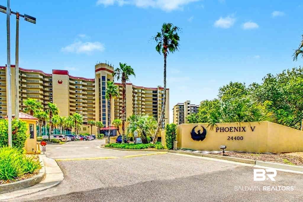 Image 4: Phoenix V building exterior featuring multiple balconies, a welcoming entry roundabout, and mature palm trees