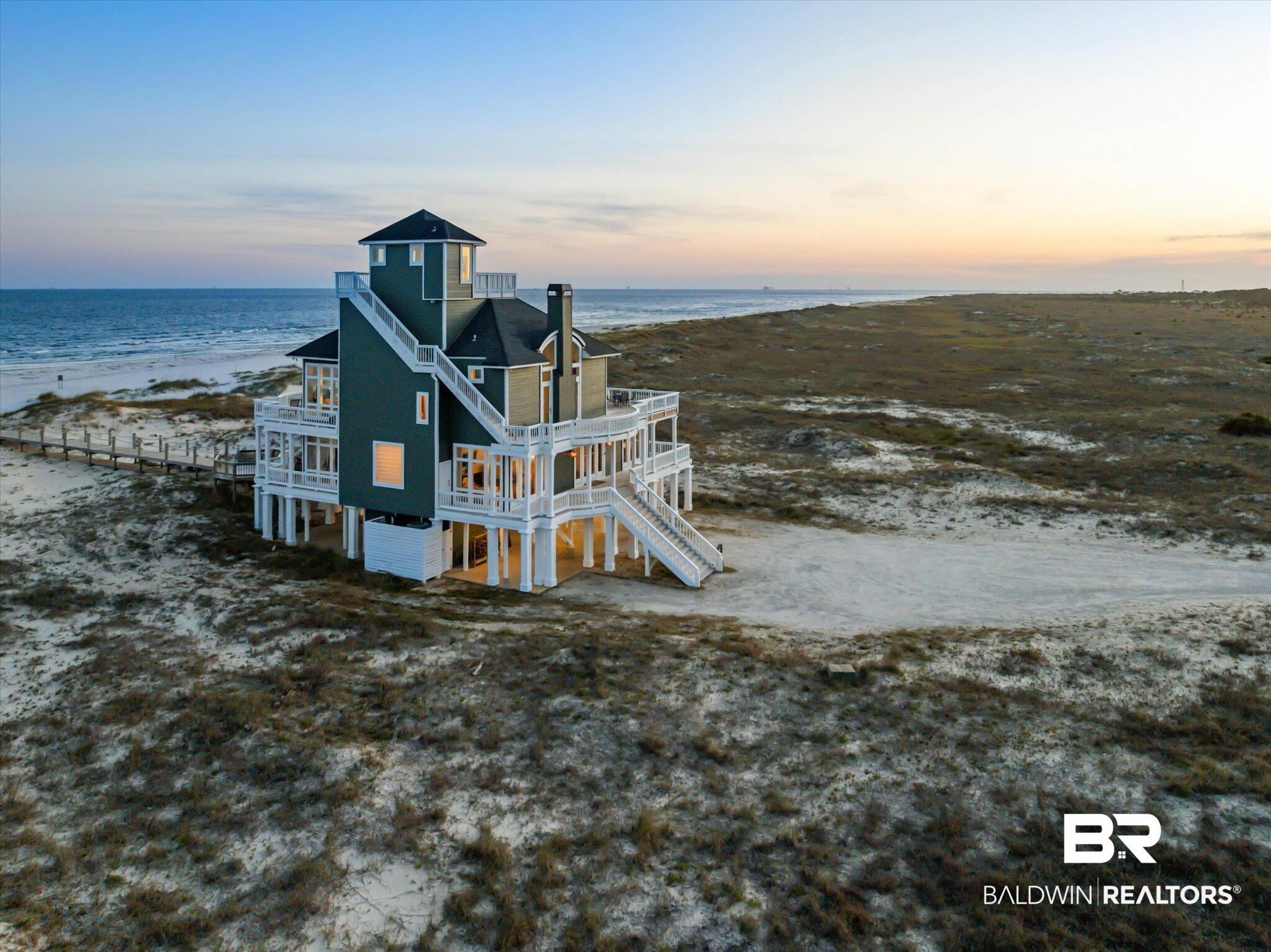 Image 3: Multi-level coastal residence featuring an elevated foundation, multiple expansive balconies, and a distinctive cupola