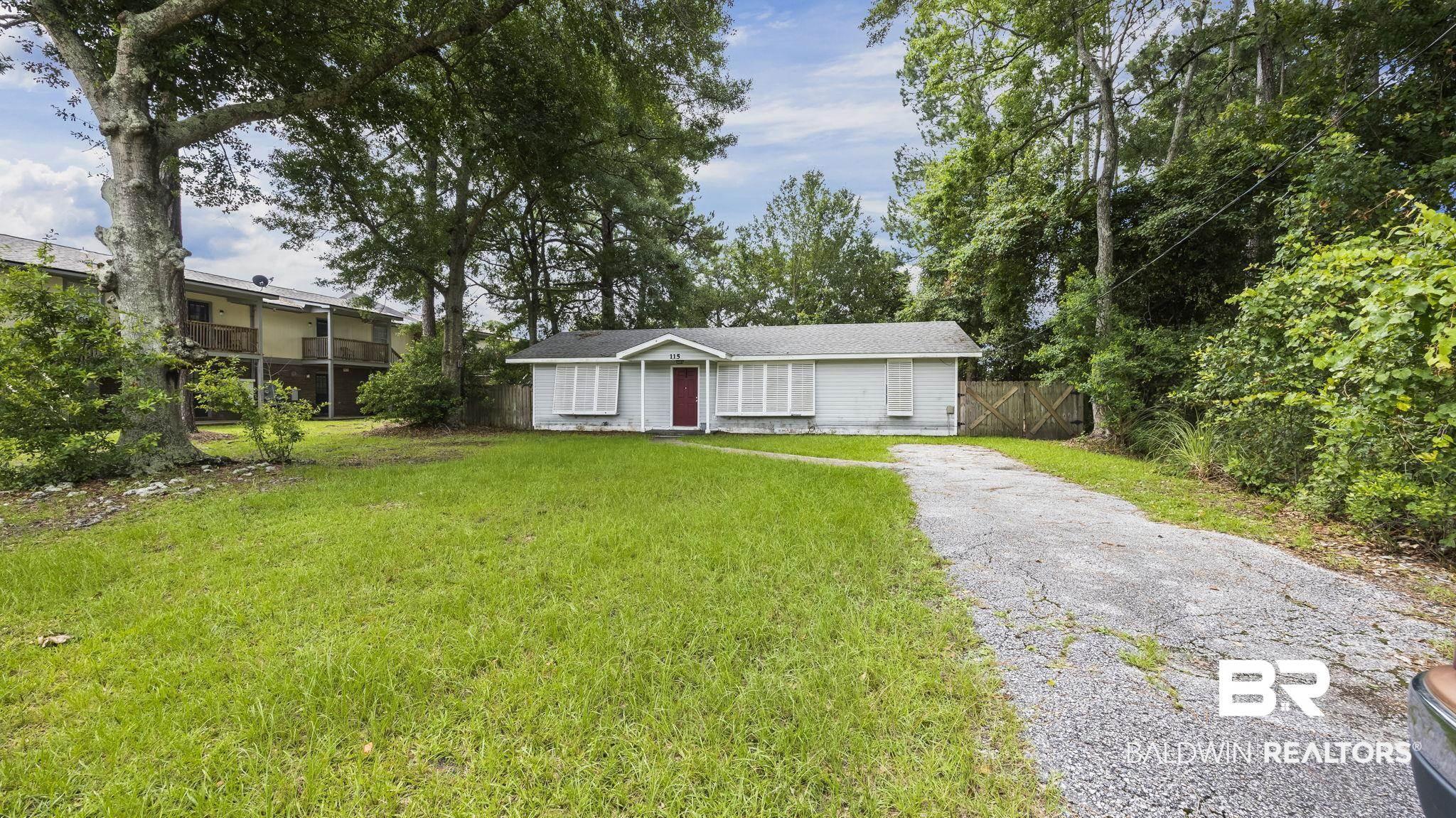 Image 2: Single-story exterior with a red entry door and white horizontal siding