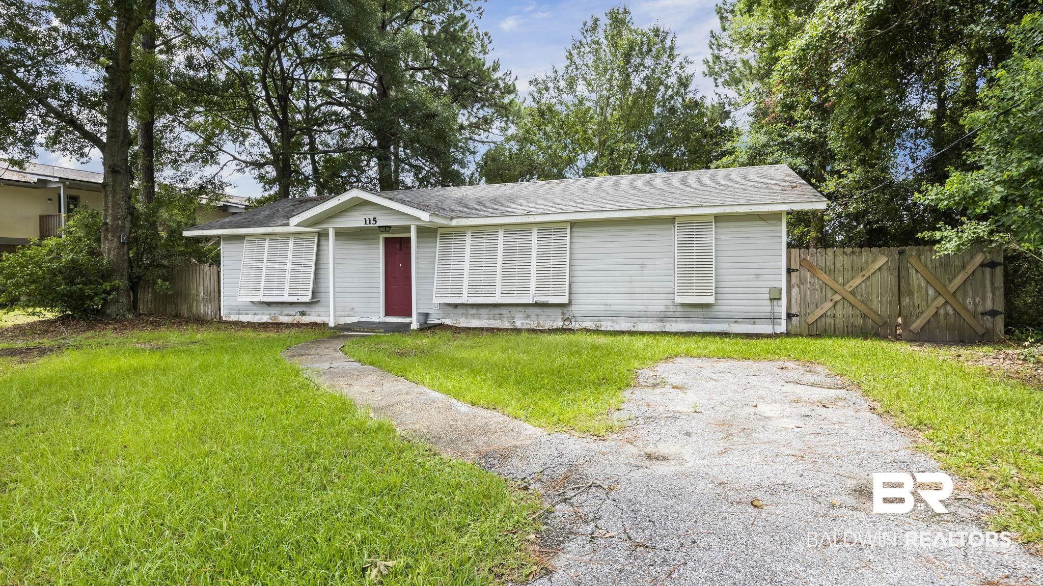 Image 3: Light-colored siding exterior with a red entry door