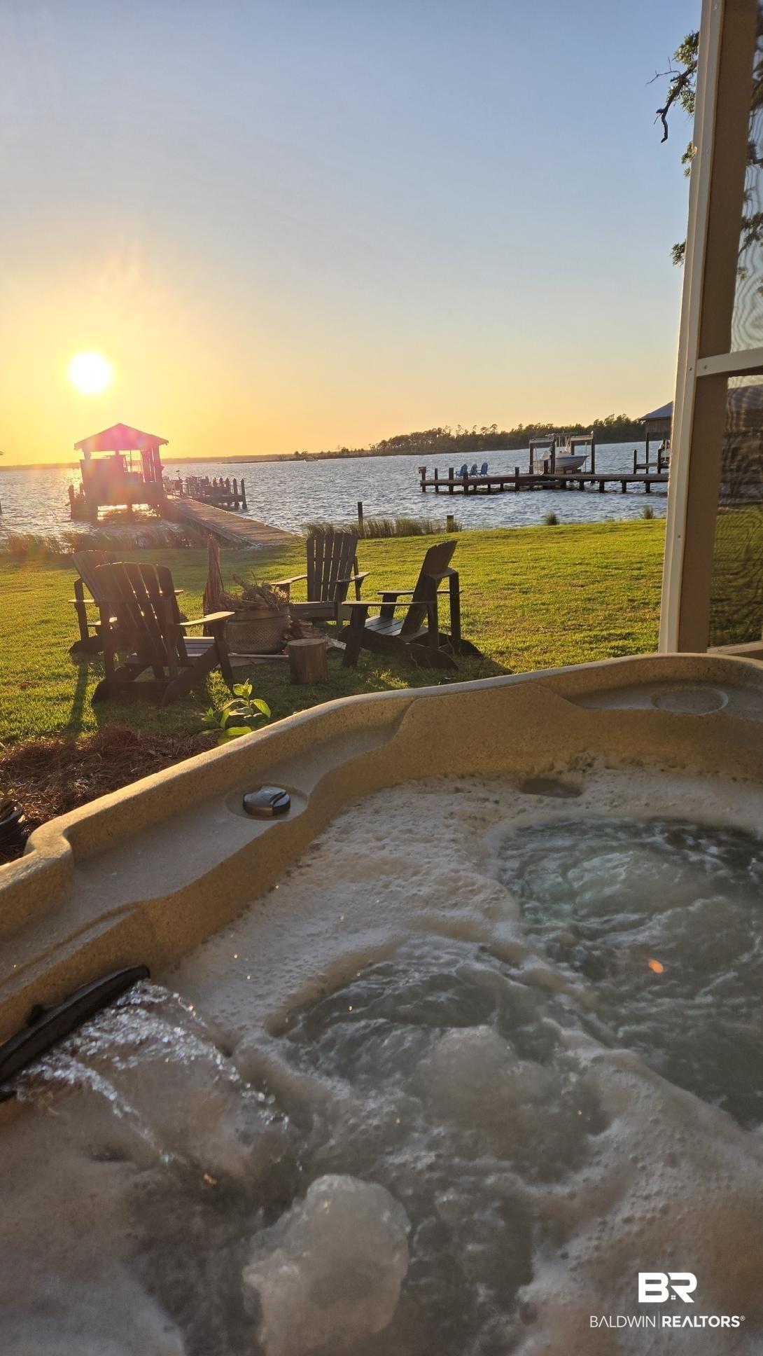 Image 4: Outdoor spa with integrated jets, complemented by a waterside setting