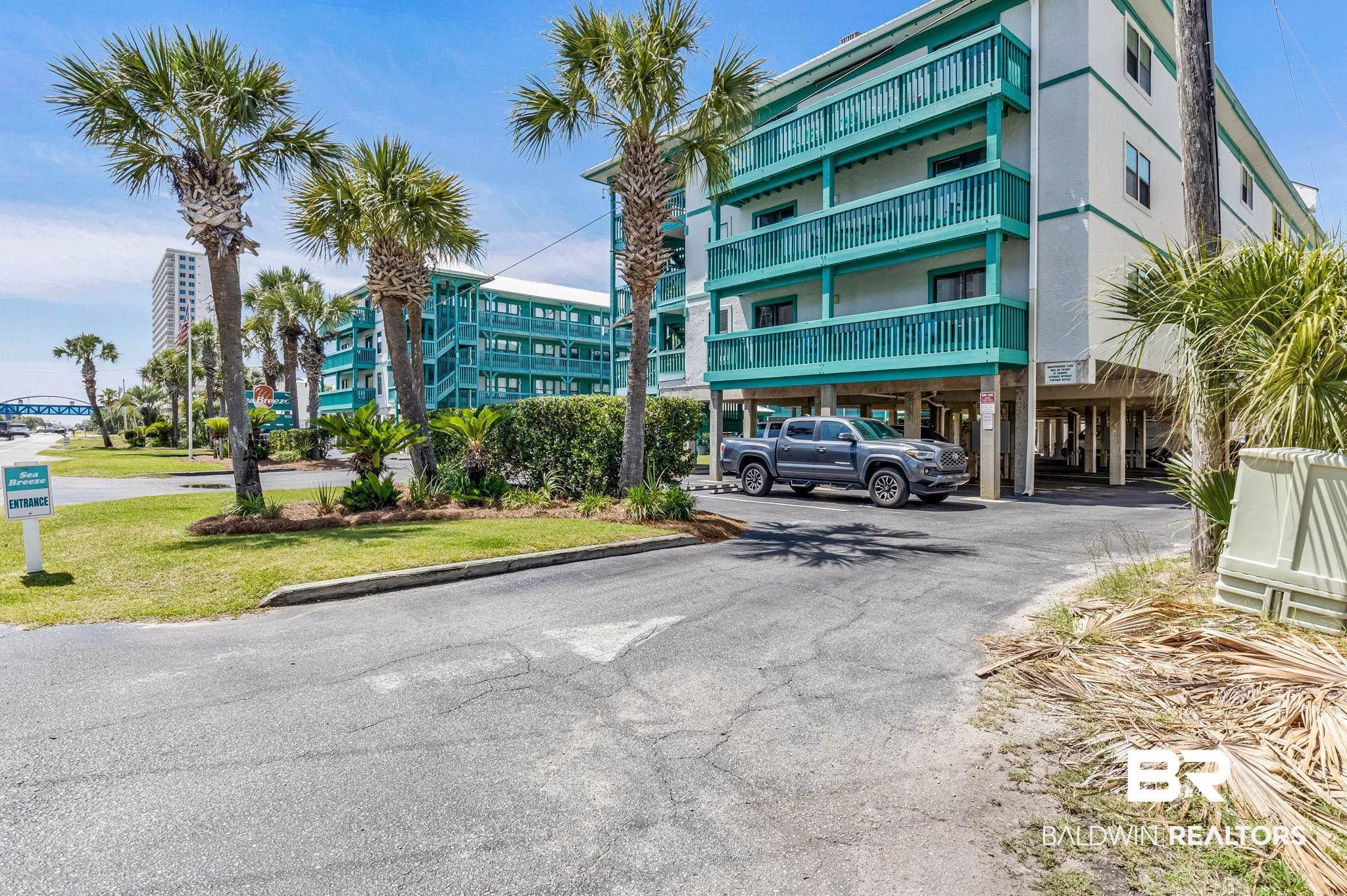 Image 4: Multi-story residential buildings featuring teal railings and white siding