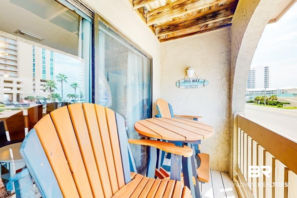 Image 2: Balcony with privacy wall, wood-plank flooring, and wood slat ceiling
