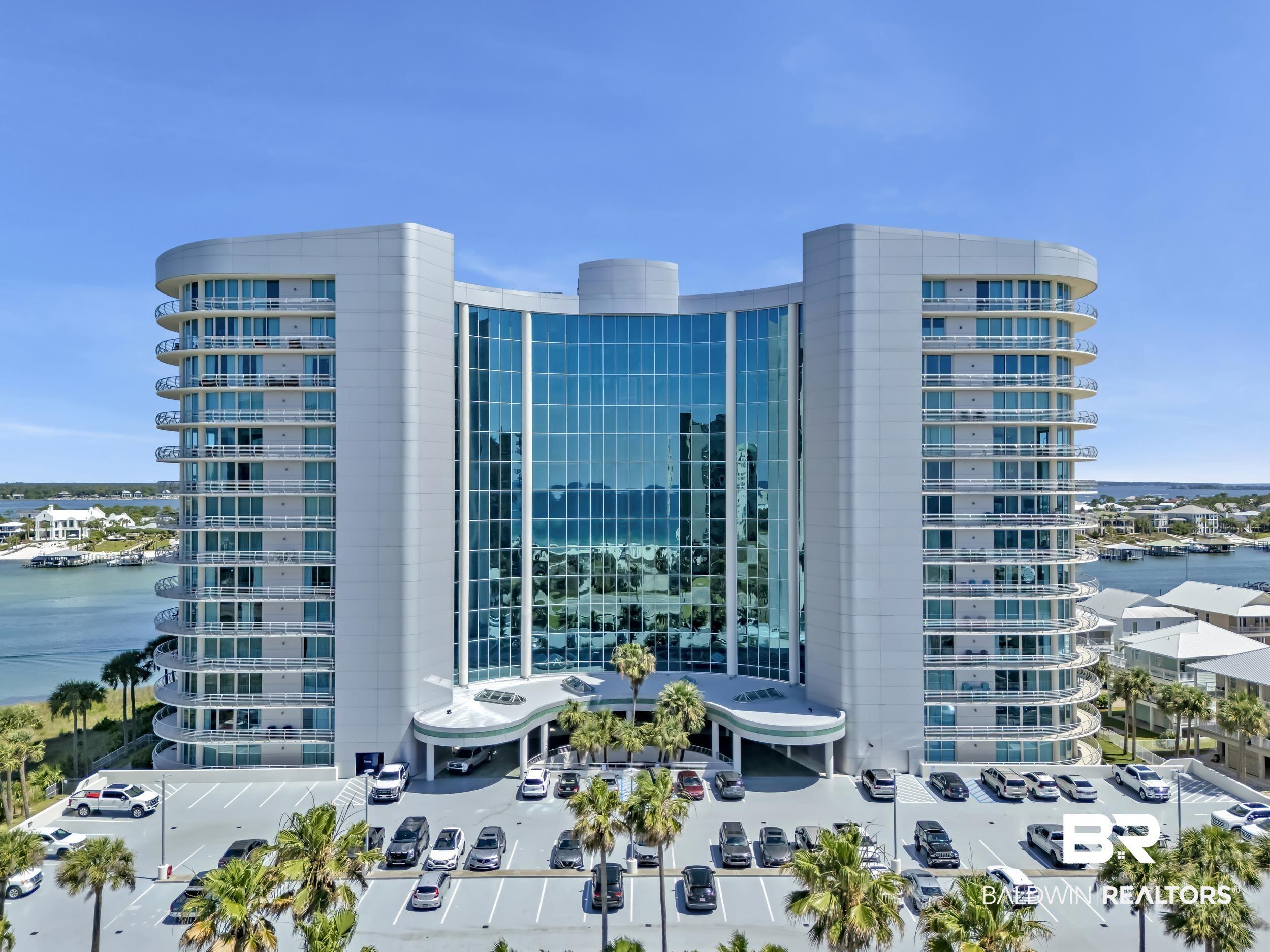 Image 2: Modern high-rise building featuring a curved glass facade and multiple balconies with glass railings