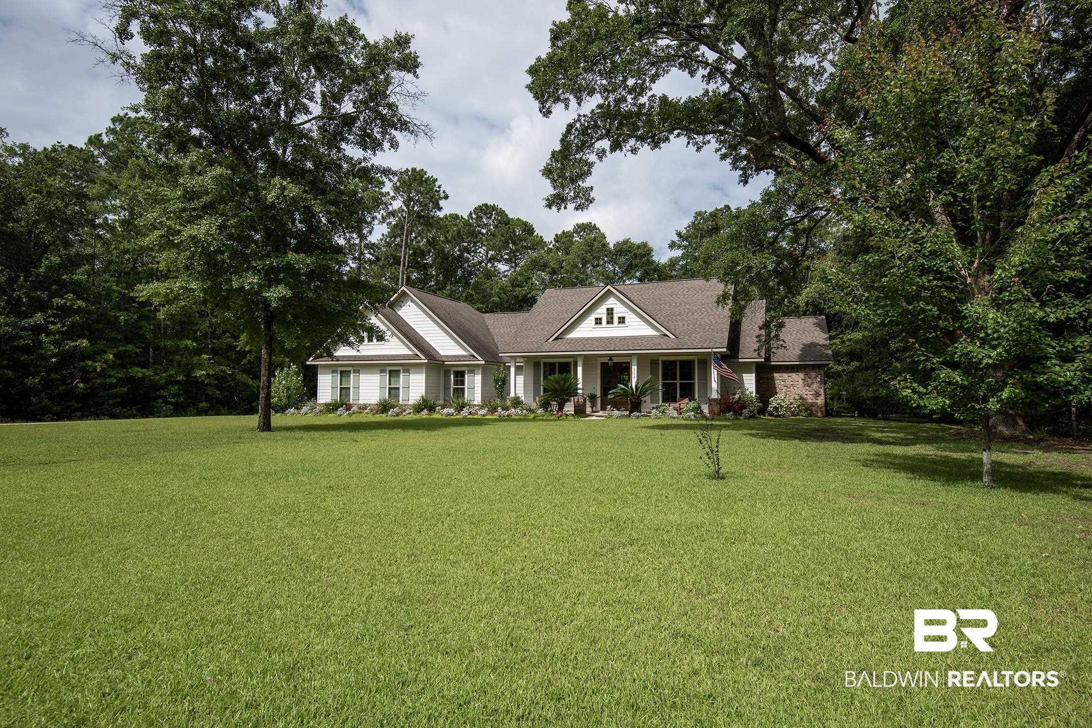 Image 3: Expansive green lawn presenting a traditional-style residence with white siding, a covered front porch, and dormer windows