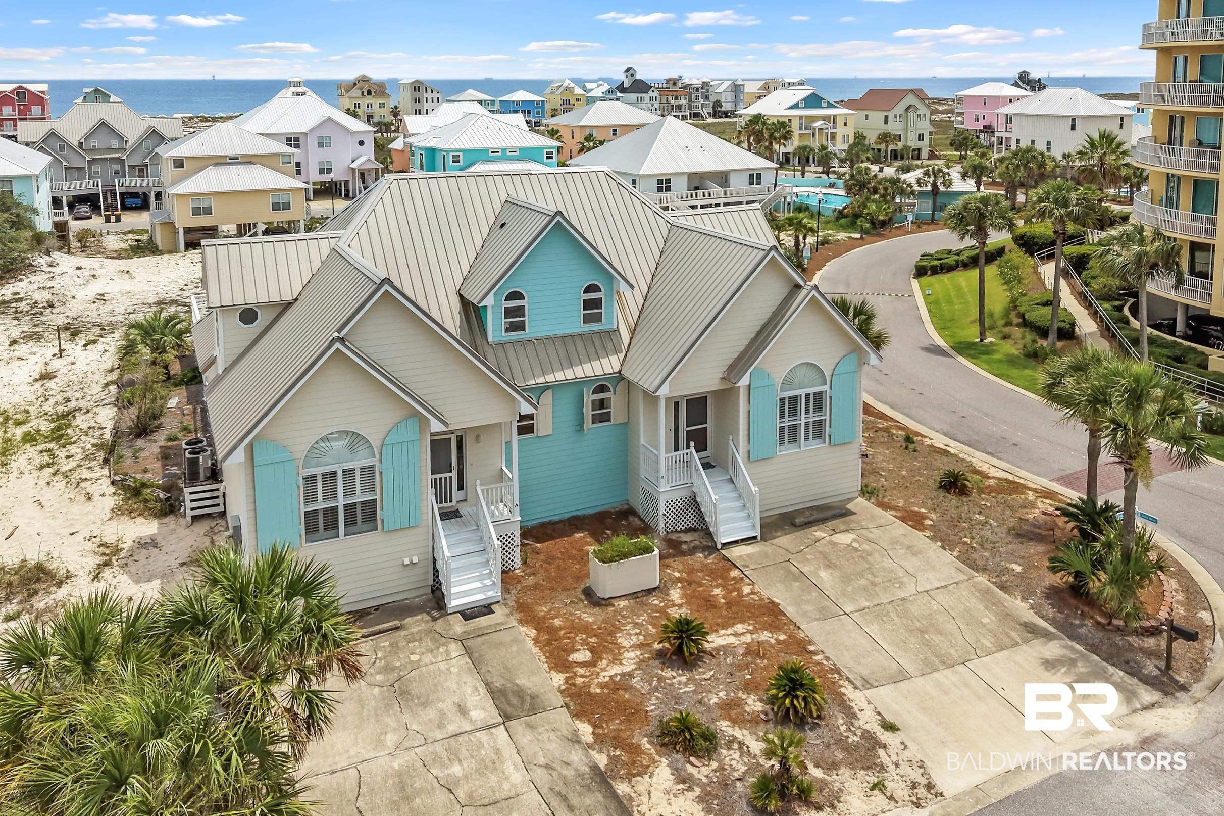 Image 4: Coastal-style property featuring a metal roof, light blue siding, and white trim accents
