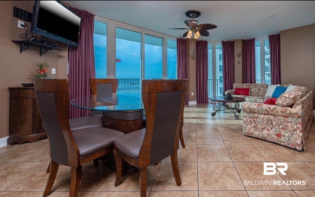 Image 4: Open-concept living area featuring extensive tile flooring and floor-to-ceiling windows