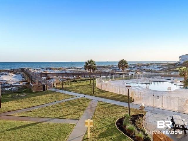 Image 4: Beachfront setting featuring a wooden boardwalk over sand dunes