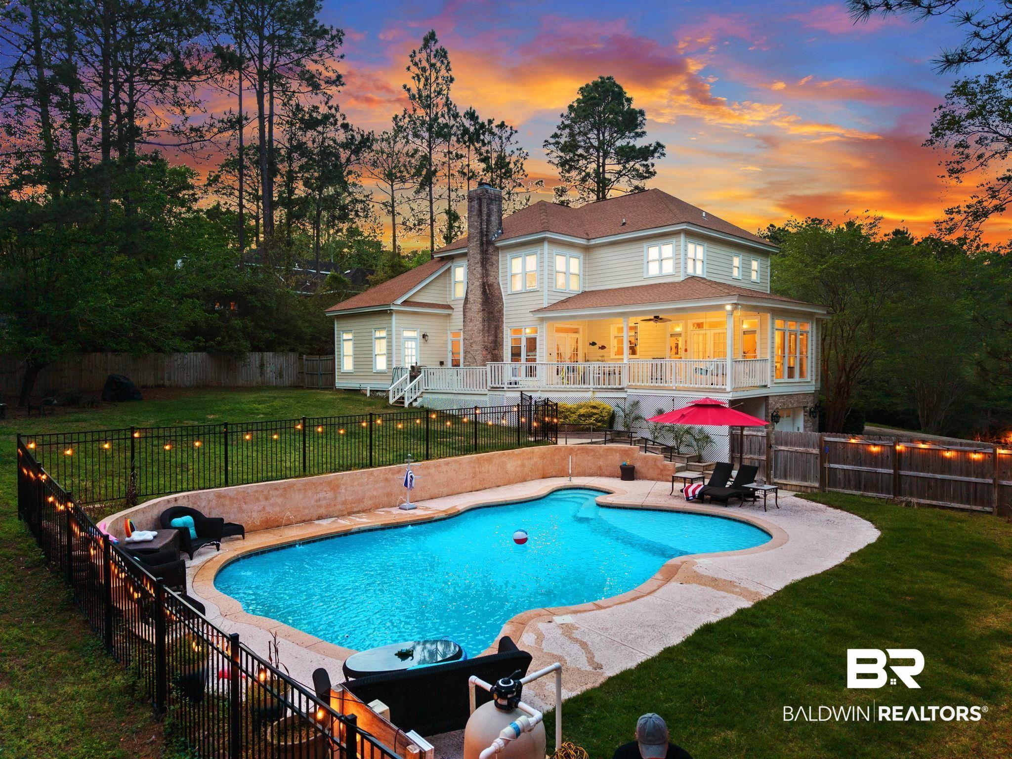 Image 3: Spacious outdoor area featuring a swimming pool with integrated spa, an elevated covered porch, and a dedicated pool equipment area