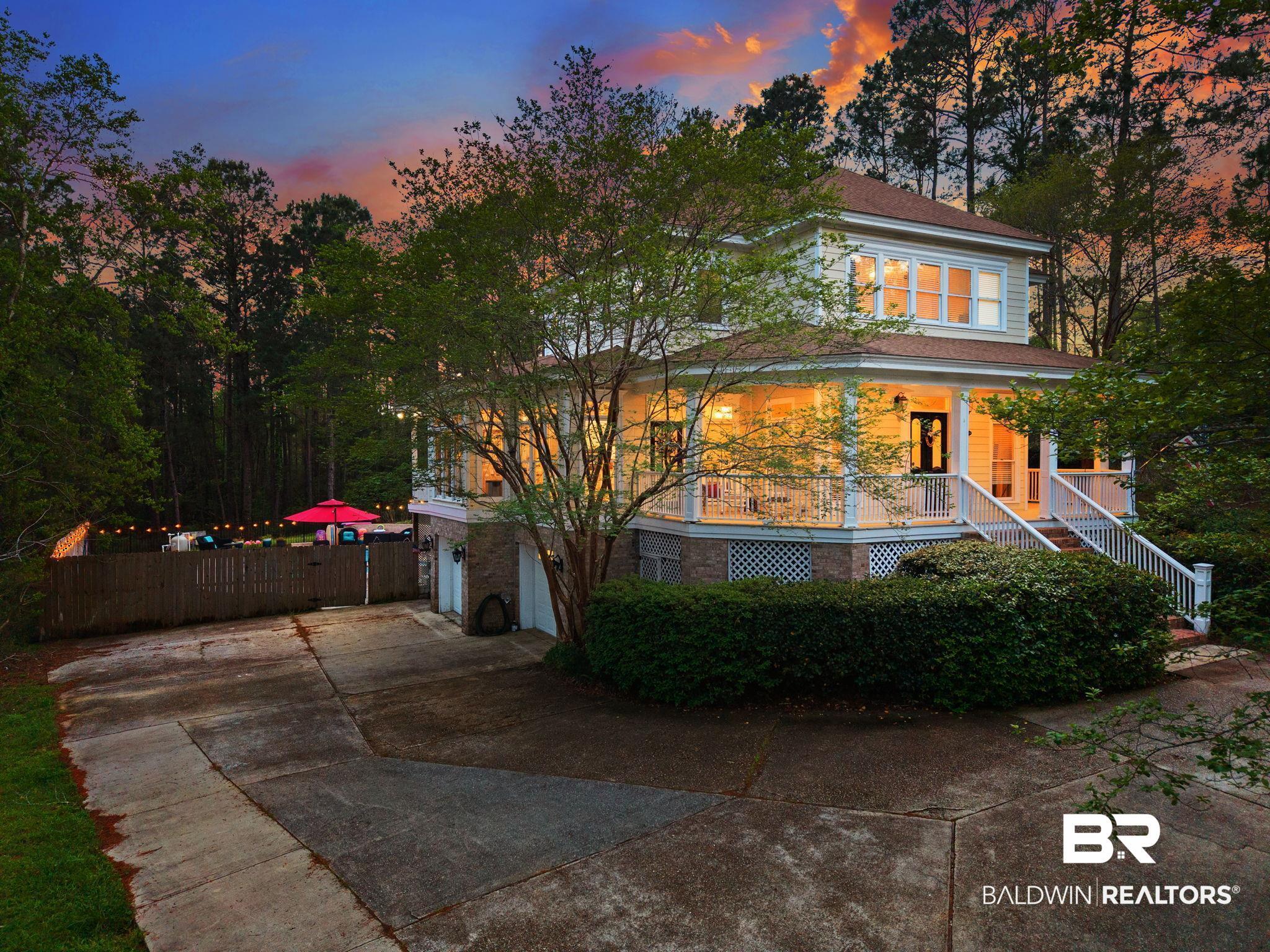 Image 4: Two-story property featuring a wrap-around porch with white railings and lattice detailing
