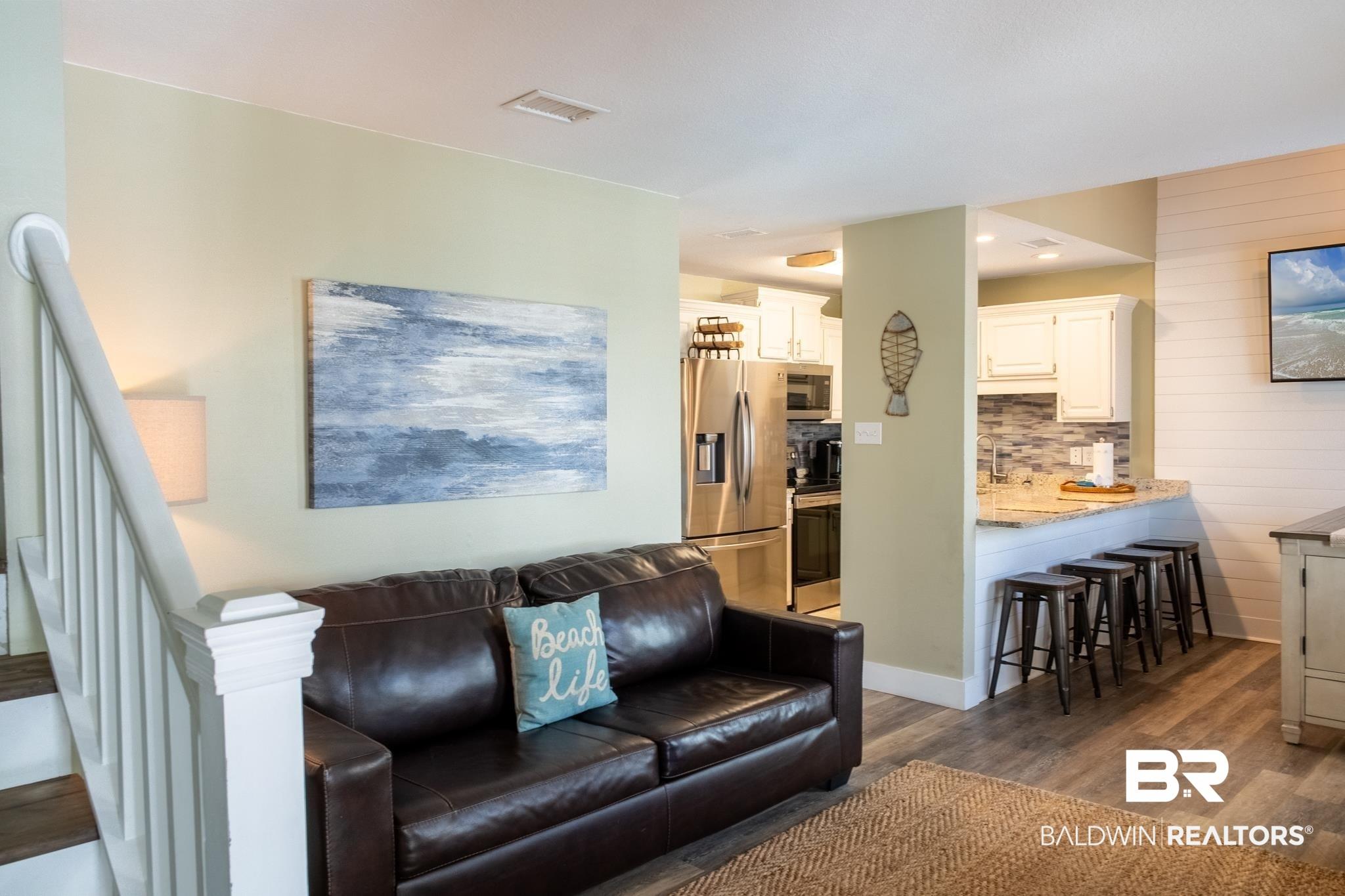 Image 4: Living room featuring stairs, dark wood-style flooring, and visible vents
