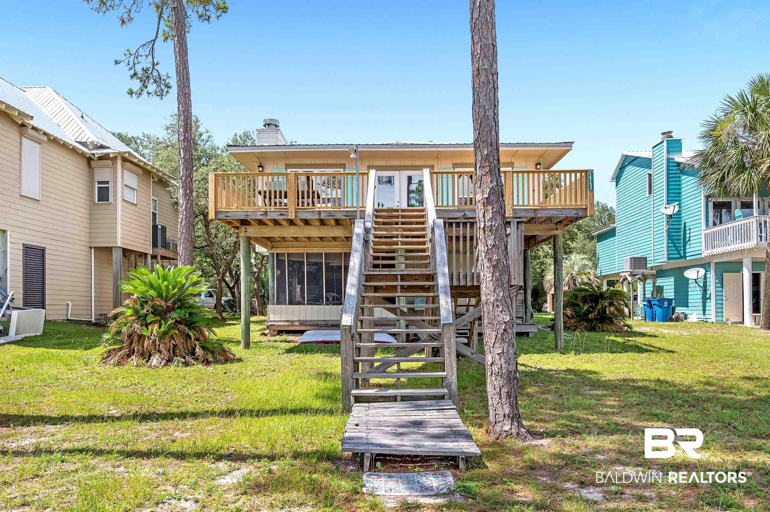 Image 3: Back of house featuring stairs, a deck, a yard, and a sunroom