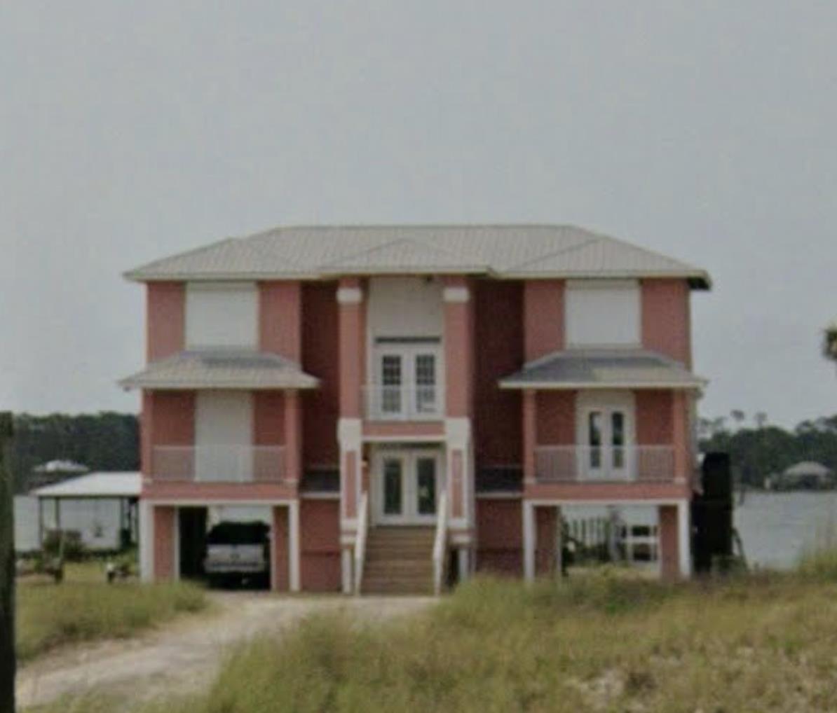 Image 1: View of front of house with french doors, a carport, and stucco siding