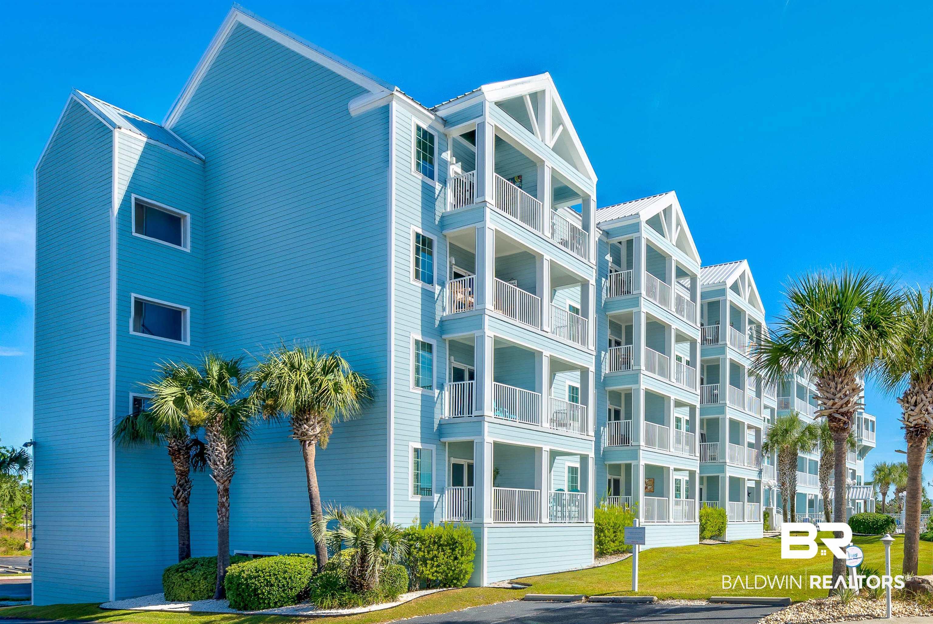 Image 2: Multilevel condominium building featuring light blue siding with white trim