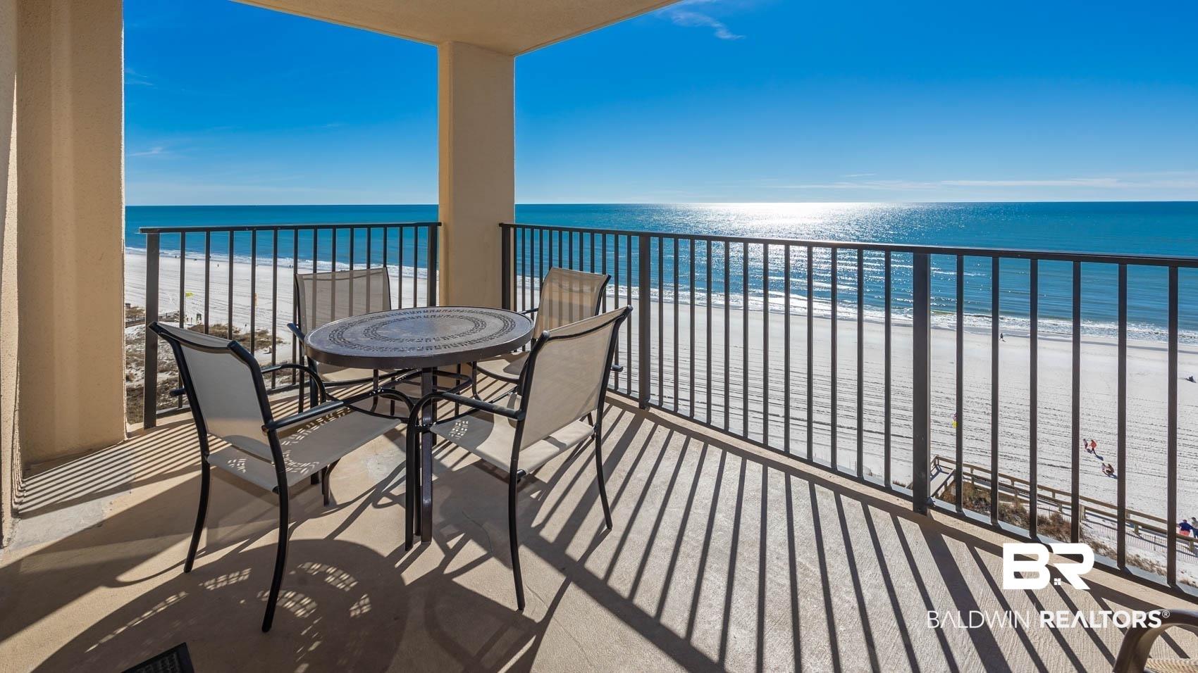 Image 2: Expansive private balcony with direct ocean frontage, offering clear views of the white sand beach and the open water