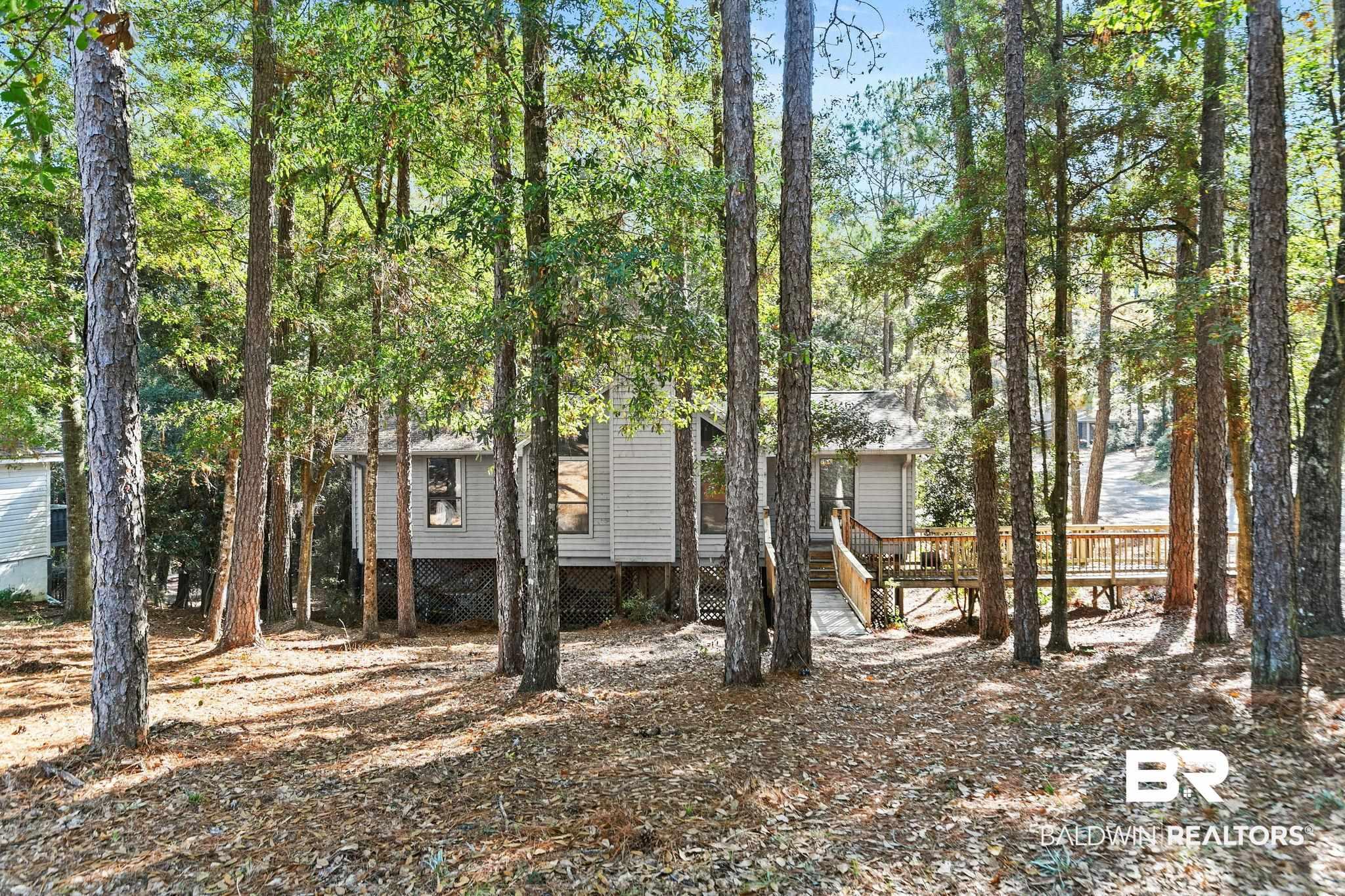Image 2: View of front of house featuring a wooden deck and stairway