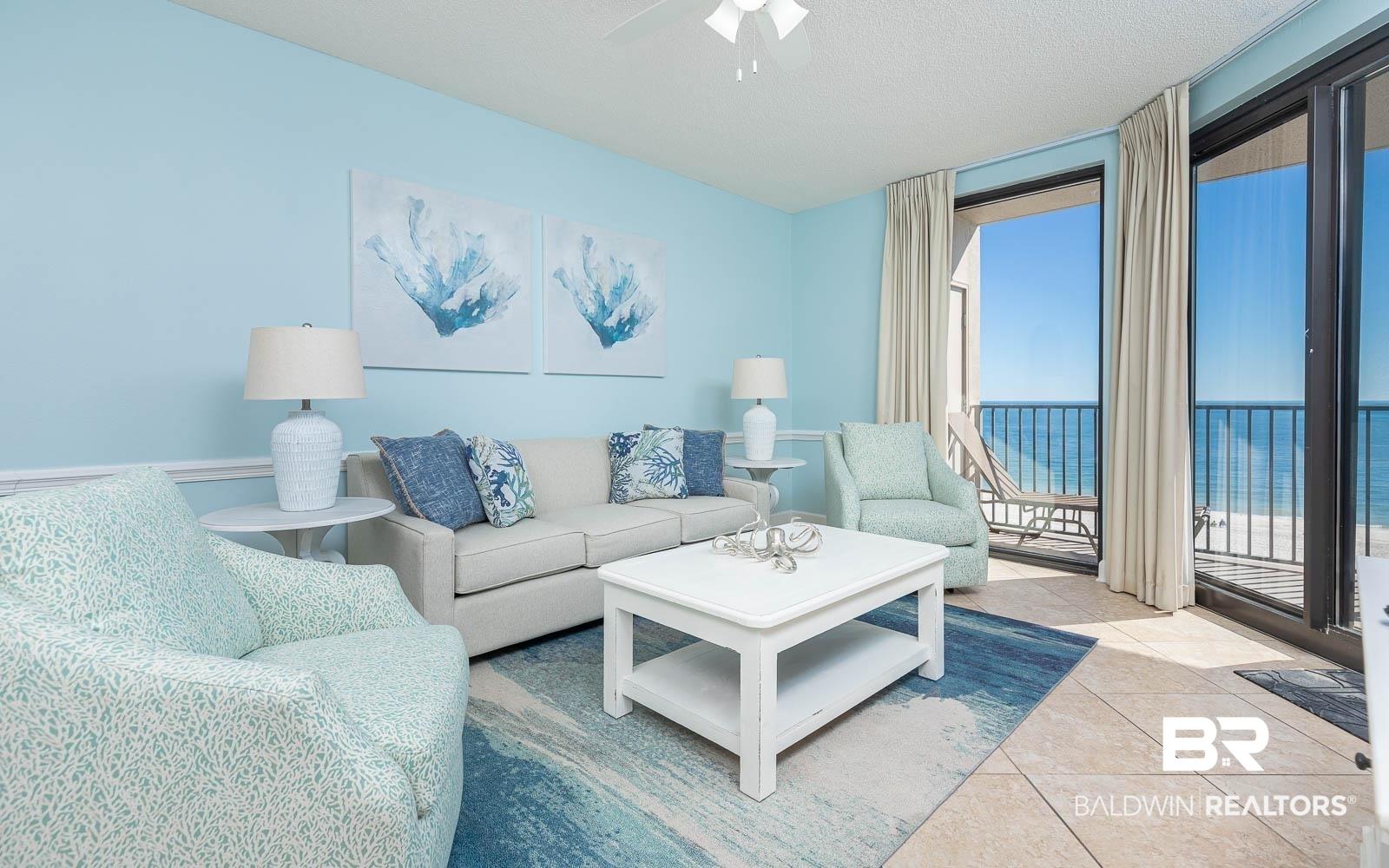 Image 2: Living area featuring light blue walls, crown molding, and large sliding glass doors opening to a balcony