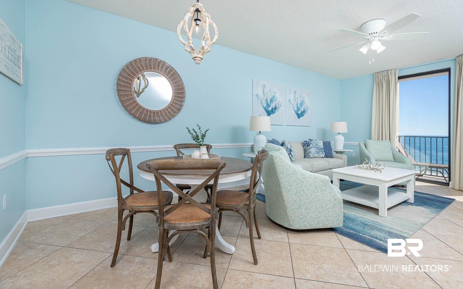 Image 3: Combined living and dining area featuring tile flooring, crown molding, and a balcony with expansive water scenery