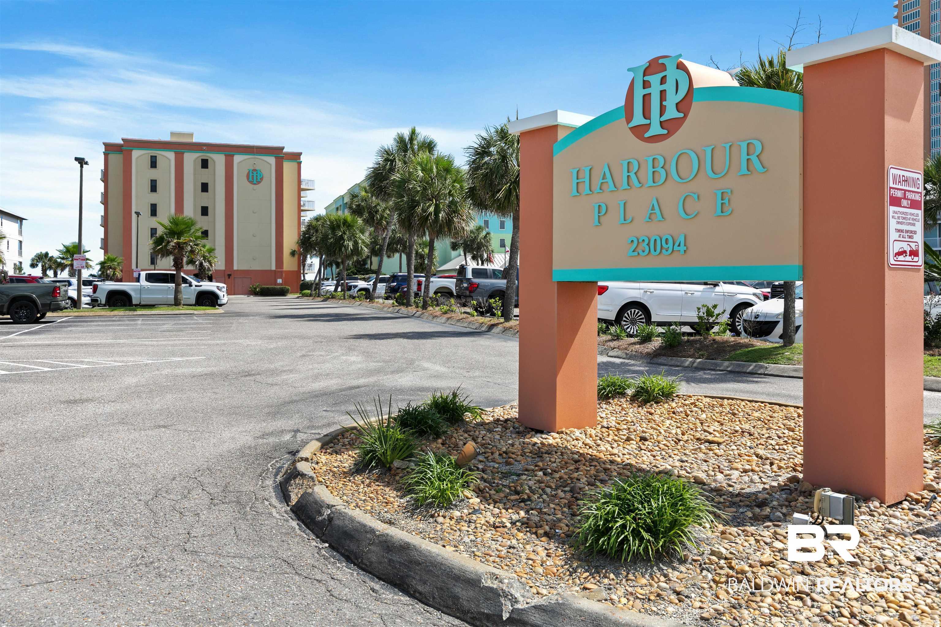 Image 1: Harbour Place signage featuring a landscaped base with decorative rocks and plantings