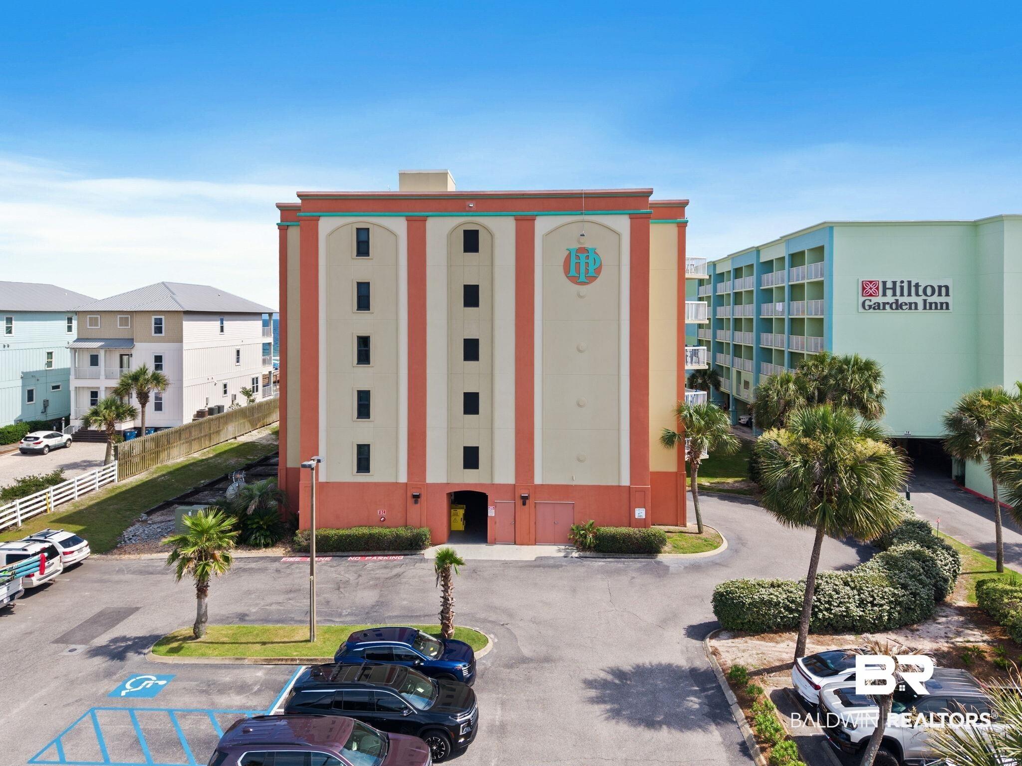 Image 2: Multi-story building featuring an orange and cream exterior with arched window details