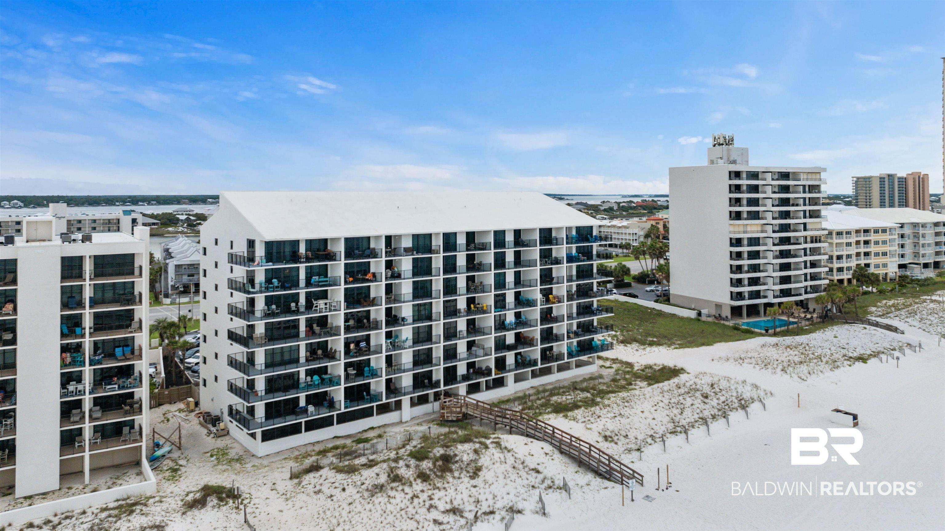 Image 1: Beachfront condominium complex featuring multiple stories of private balconies