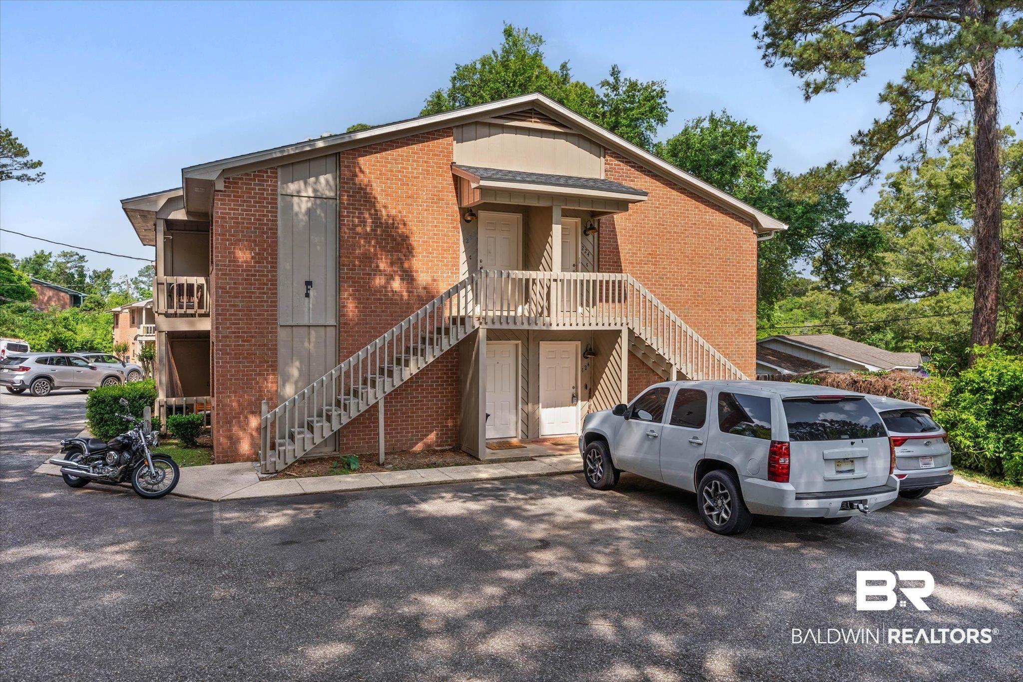 Image 2: Brick facade multi-story building featuring outdoor staircases and private balconies