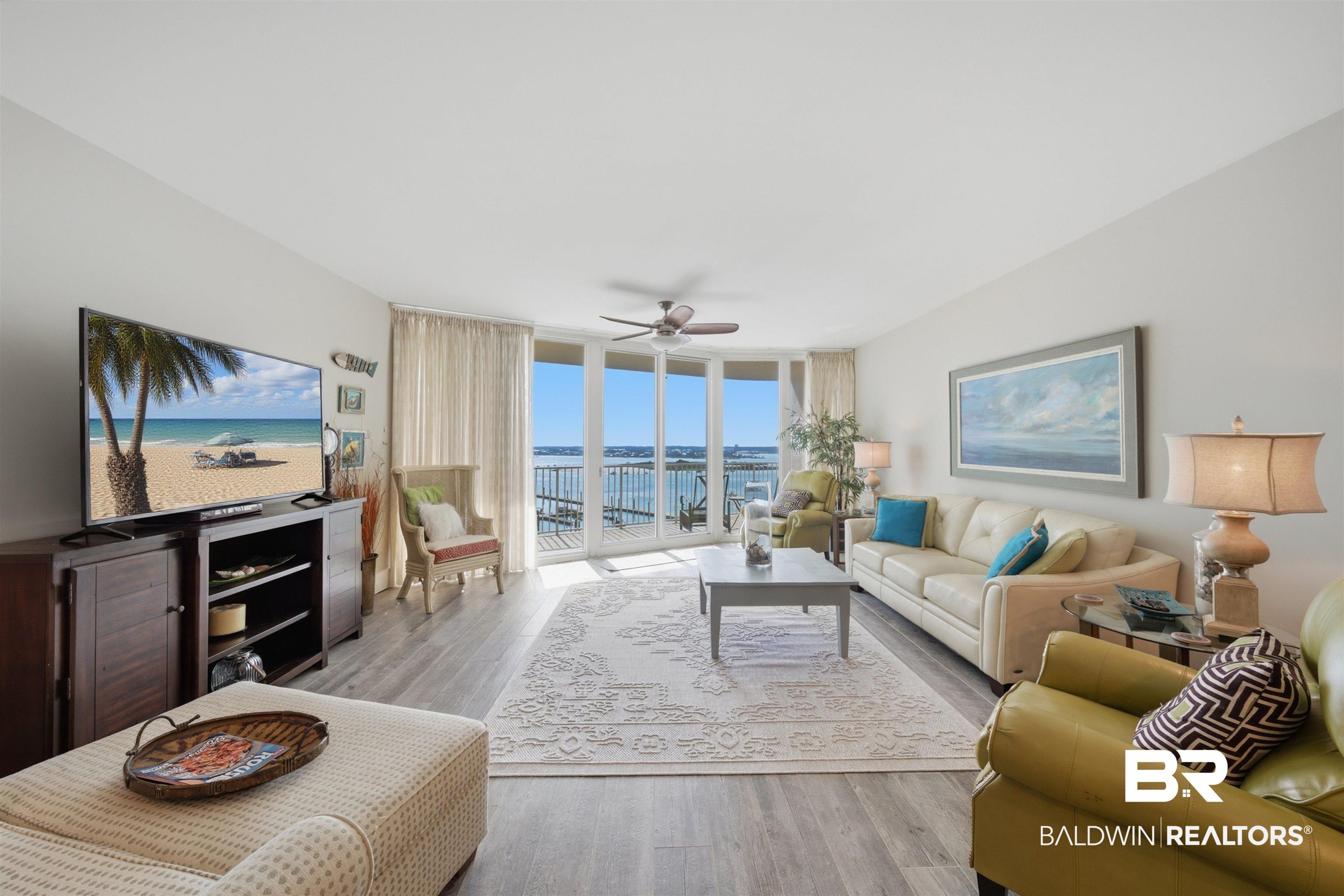 Image 2: Expansive living area with grey-toned wood-finish flooring and light wall finishes