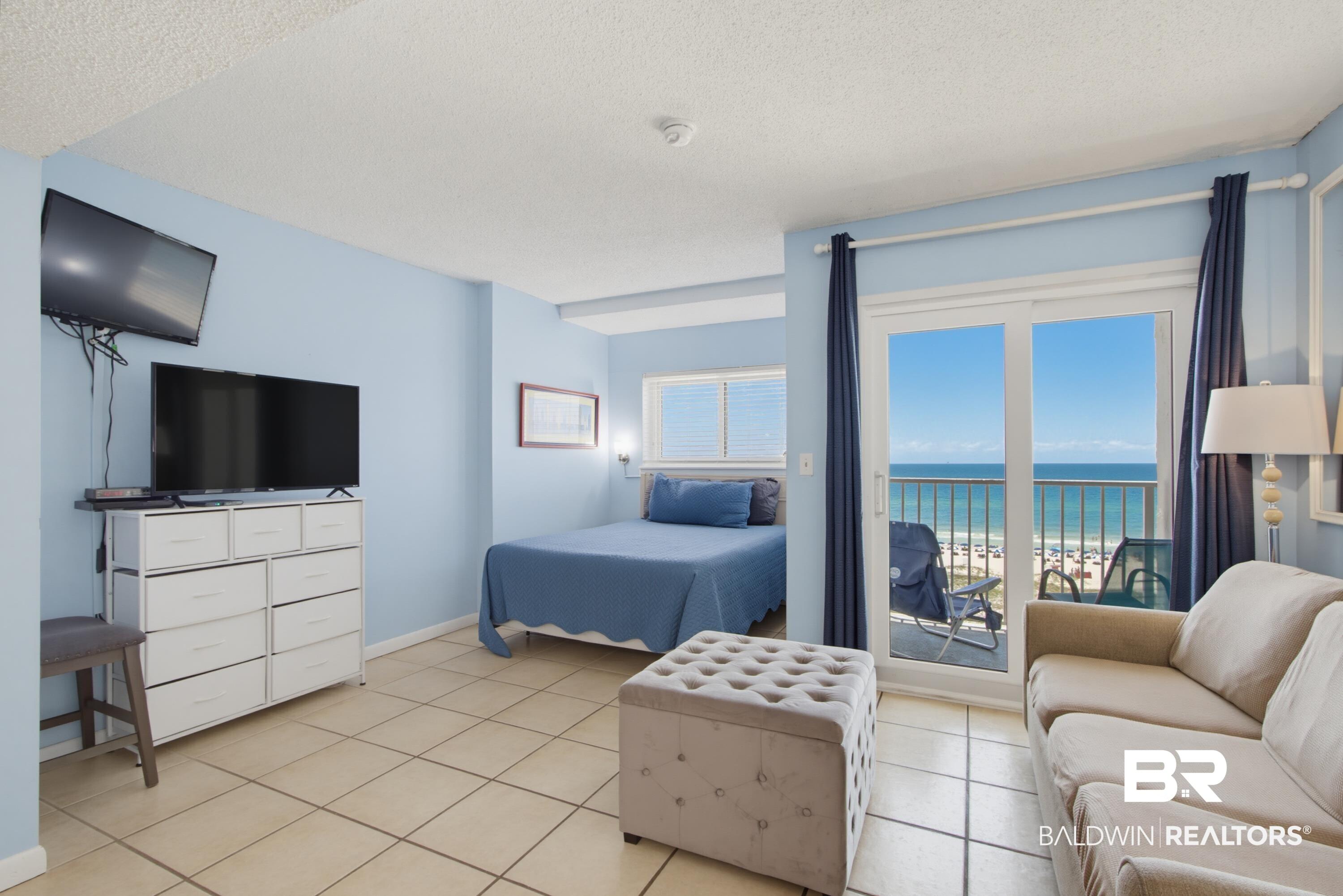 Image 3: Sliding glass doors opening to a balcony with an ocean backdrop