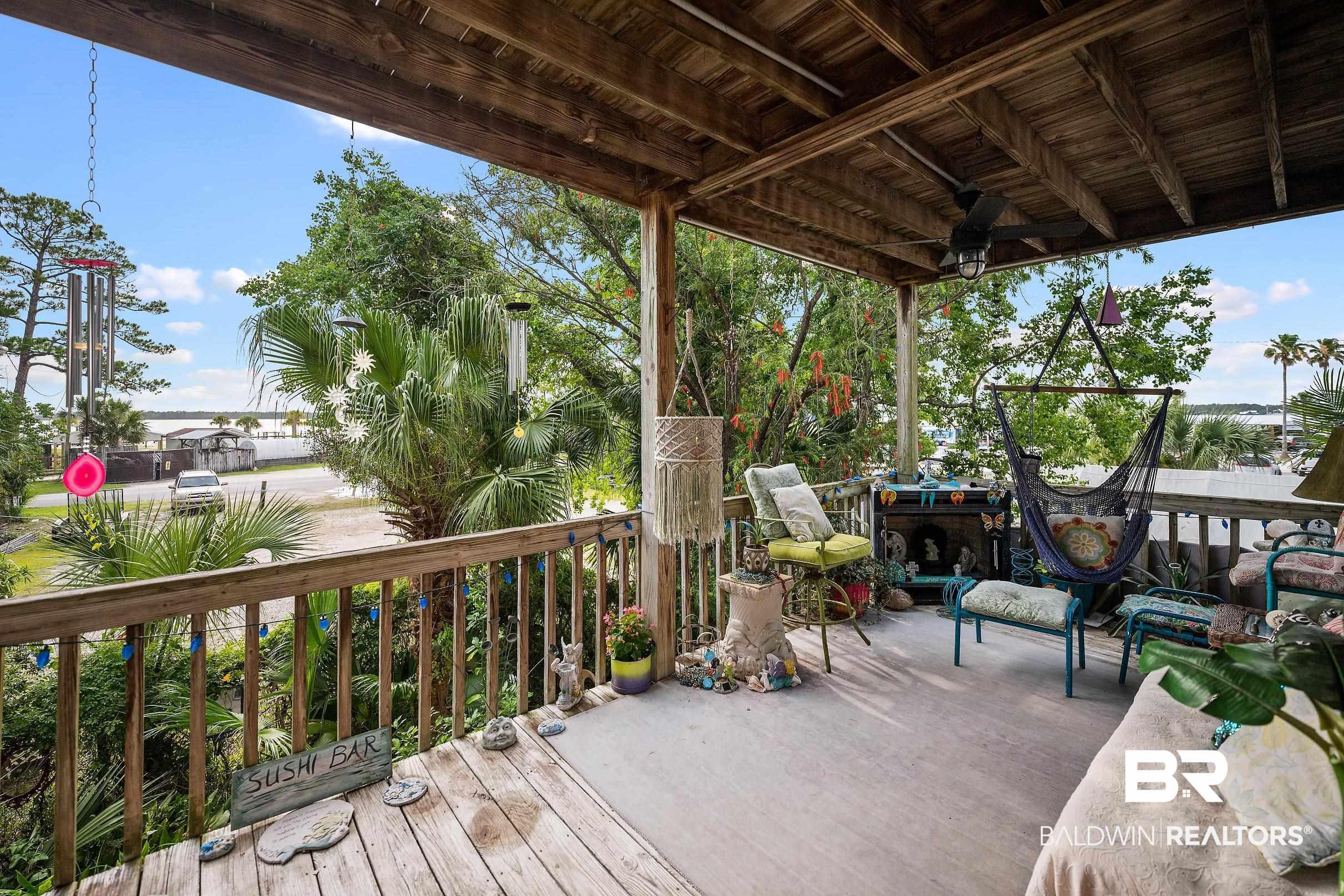 Image 4: Expansive covered porch featuring wood-finish flooring, a wood-beam ceiling, and a ceiling fan