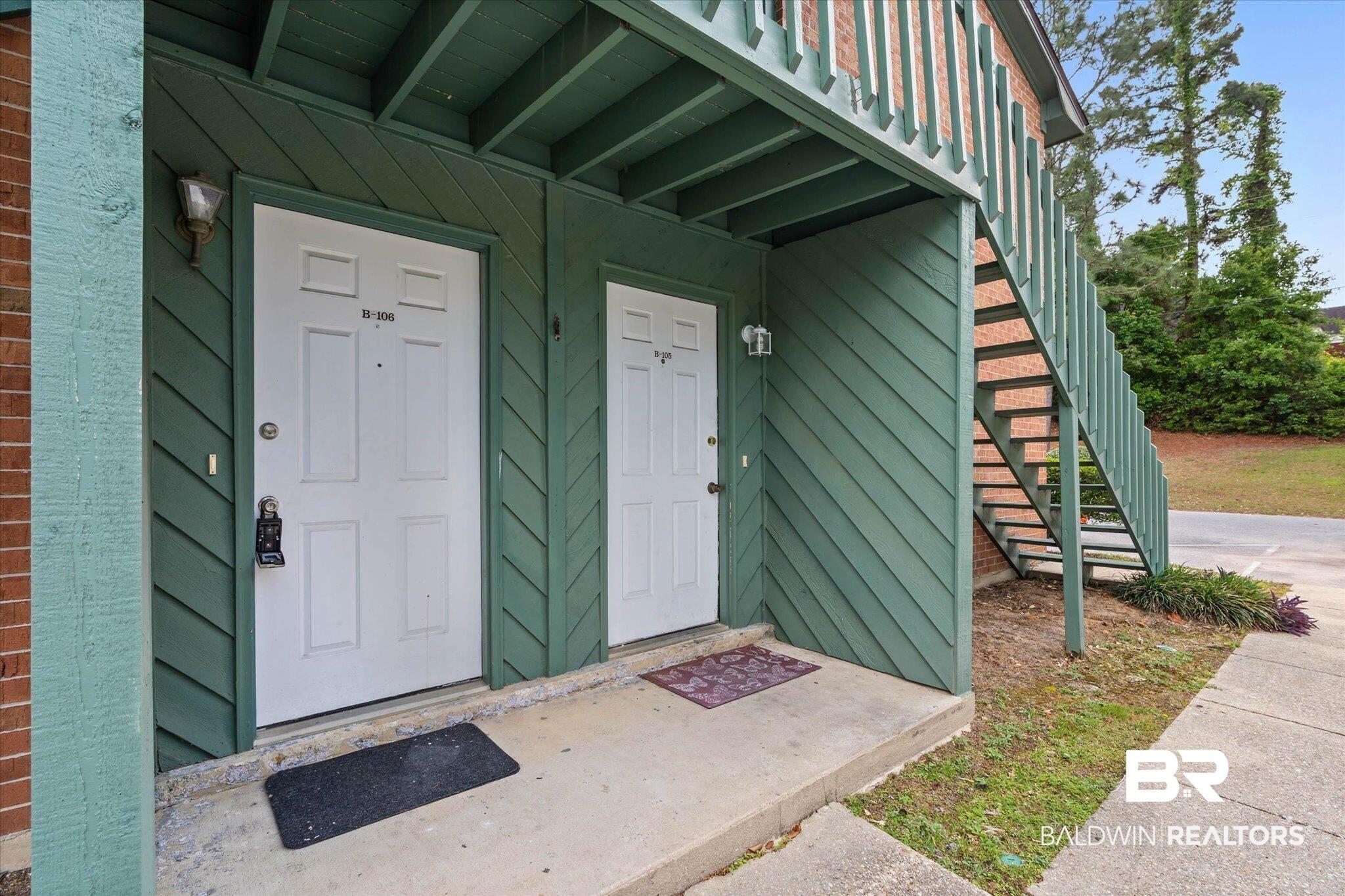 Image 2: Ground-level entryways featuring white paneled doors and wall-mounted exterior lighting