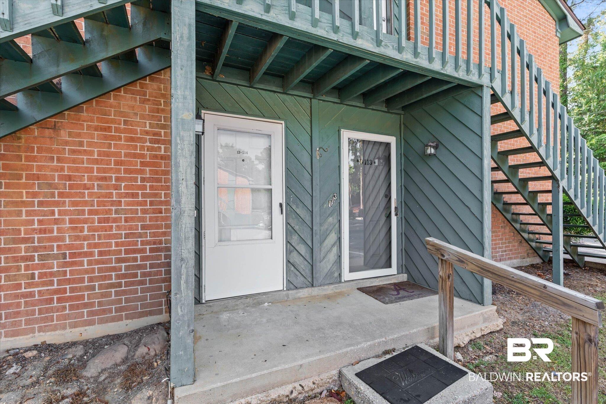 Image 2: Exterior entrance featuring brick veneer siding, horizontal lap siding, and an overhead deck structure