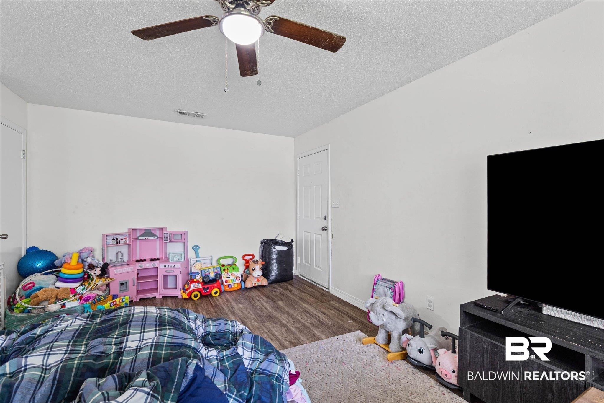 Image 4: Interior space featuring wood-finish flooring, white walls, and a ceiling fan with integrated lighting