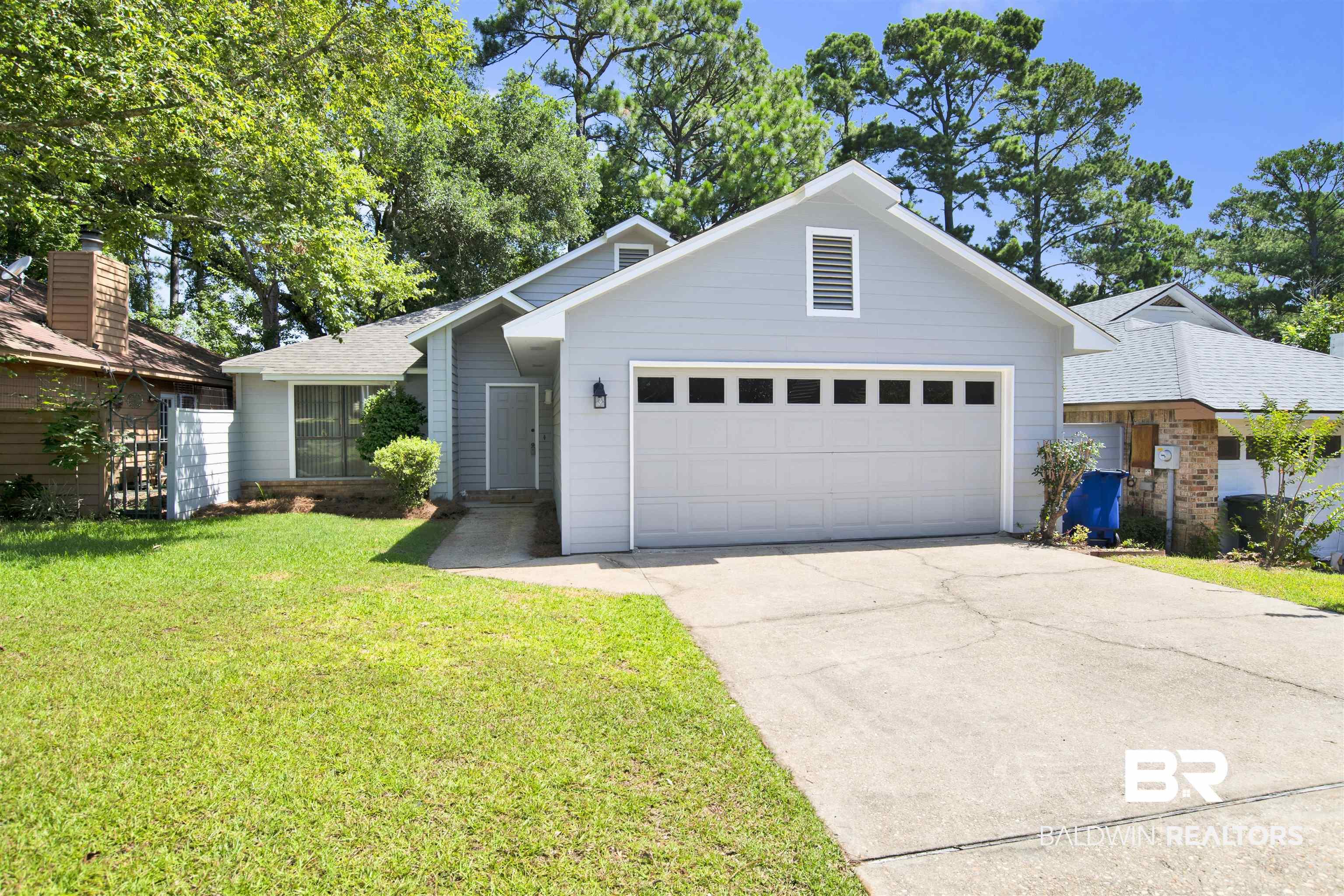 Image 3: Light gray siding exterior with a two-car garage featuring square window inserts