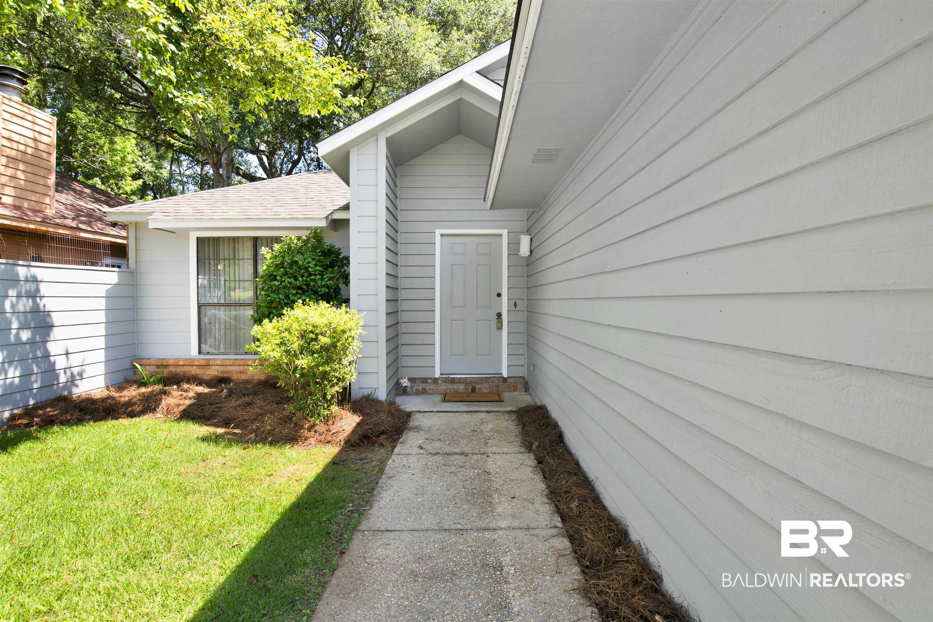 Image 4: Light gray horizontal siding exterior with a concrete walkway