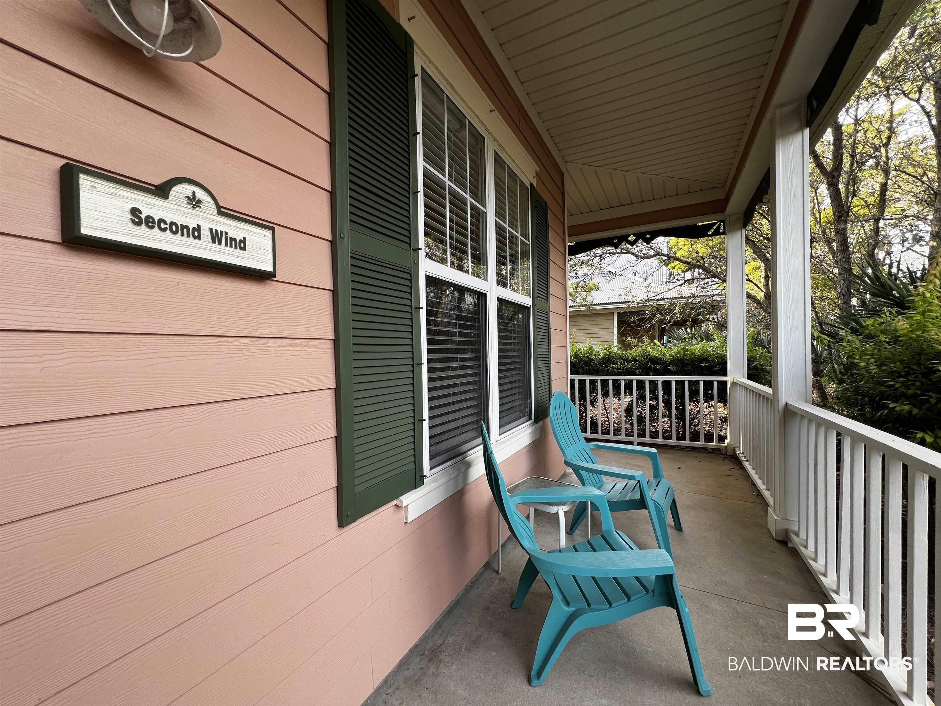 Image 3: Covered front porch featuring a plank ceiling, concrete flooring, decorative railing, horizontal siding, and functional louvered shutters