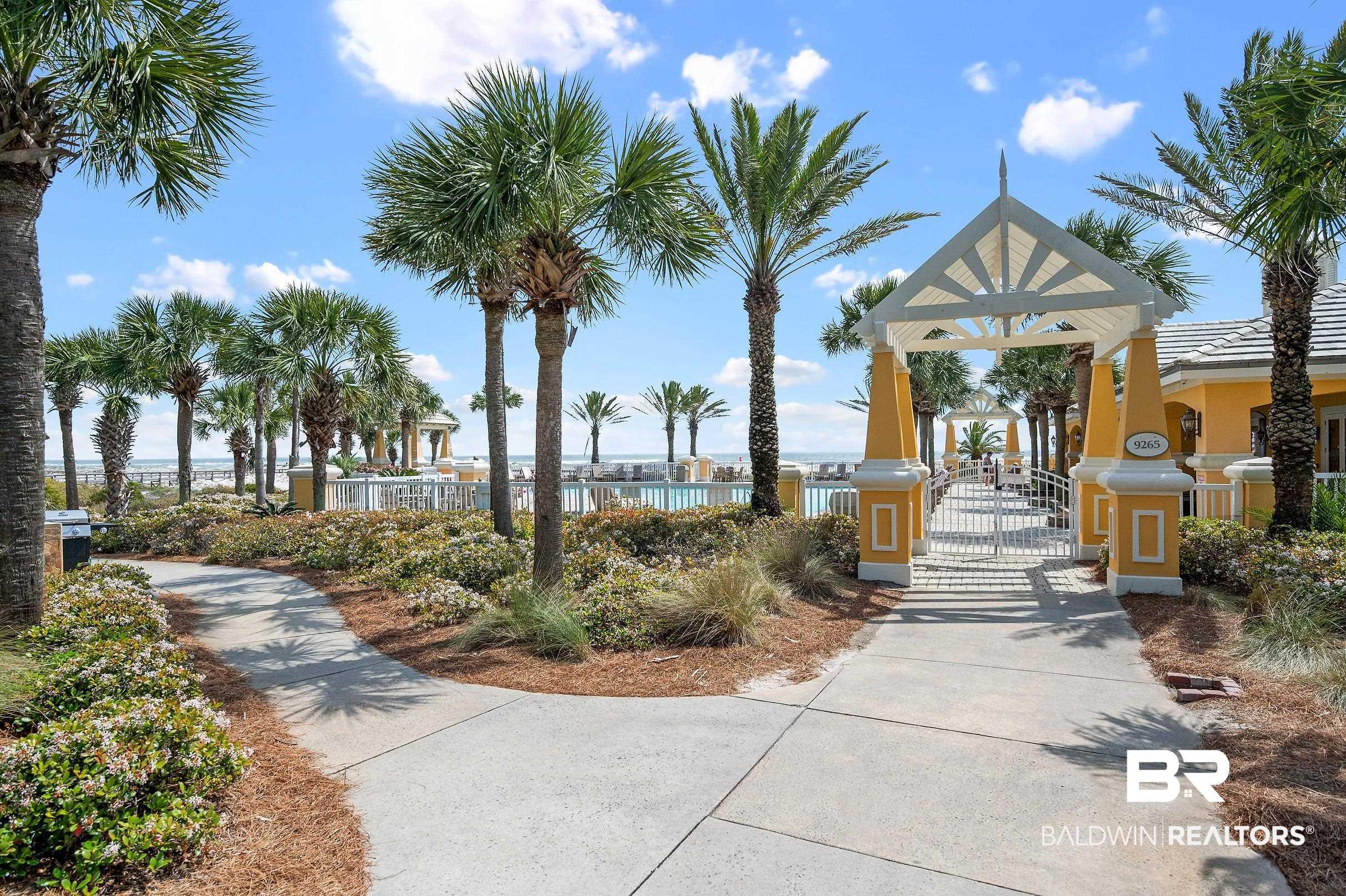 Image 4: Landscaped walkway leading to a gated entry arbor