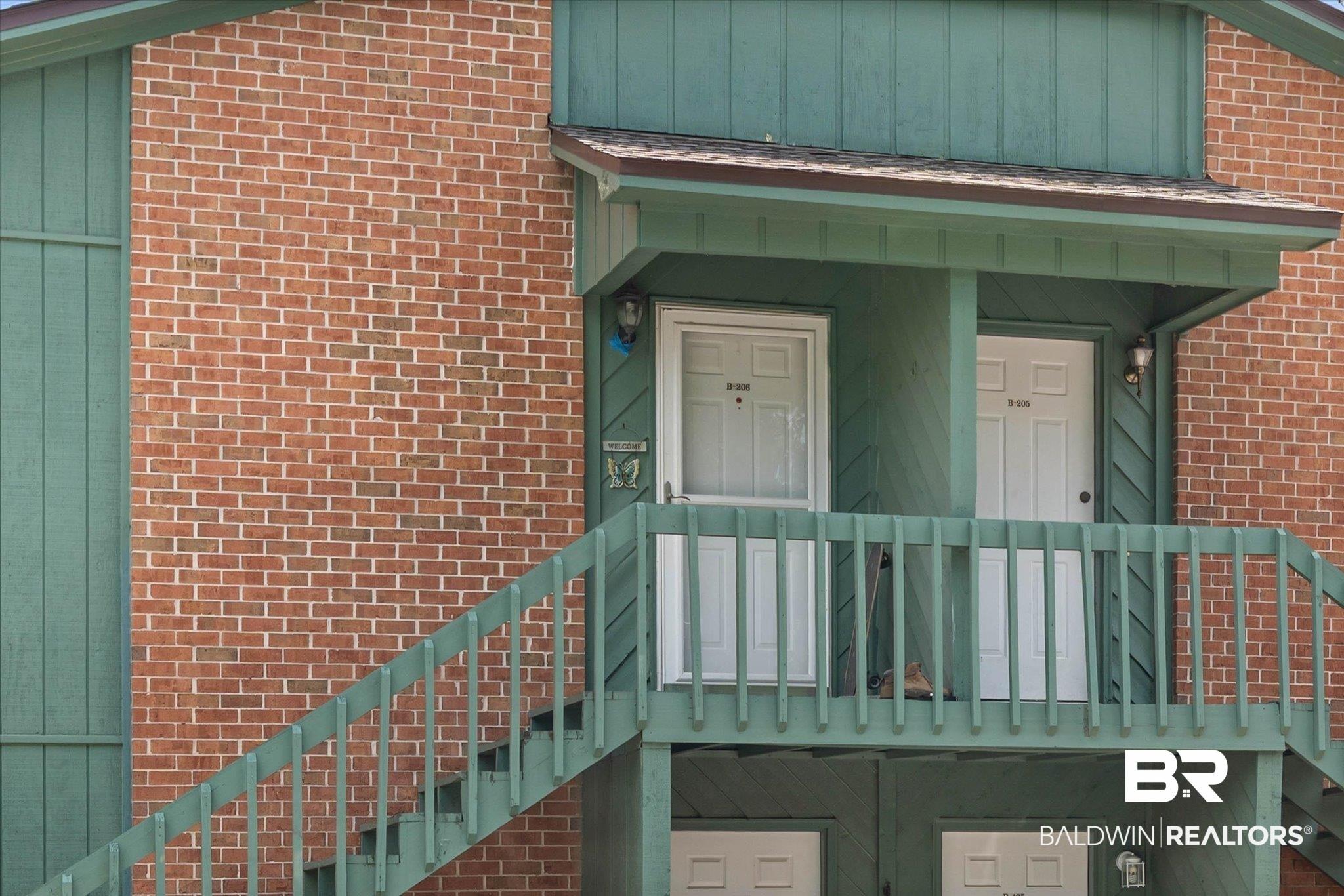 Image 2: Brick exterior with green vertical siding accents