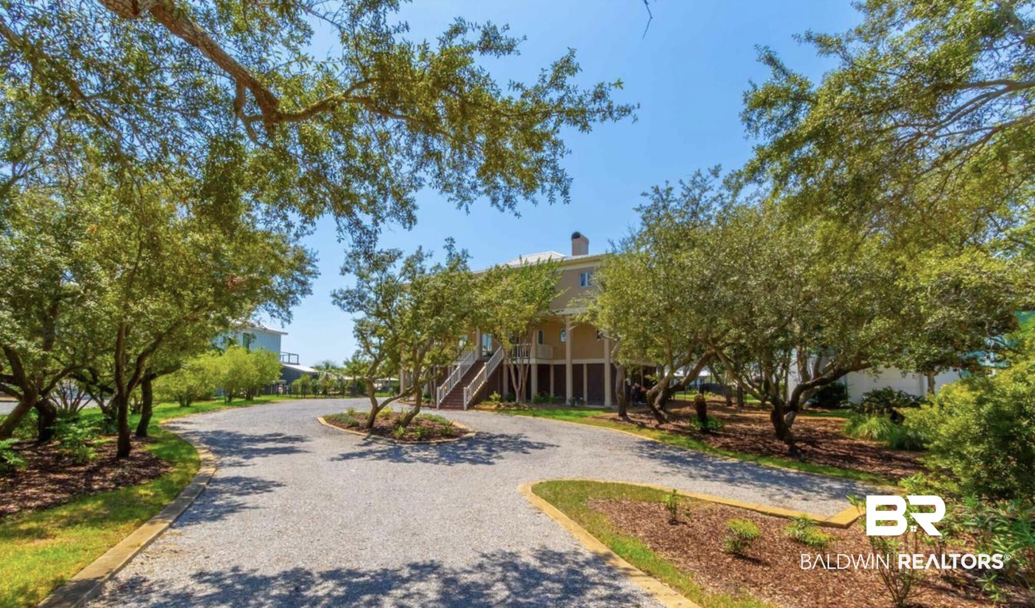 Image 4: Expansive gravel driveway bordered by mature trees and landscaped beds