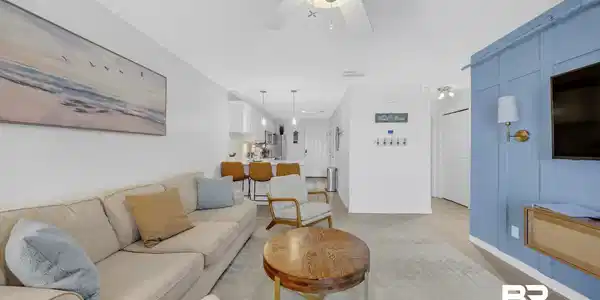 Image 4: Open-concept living area featuring light-colored walls and a ceiling fan