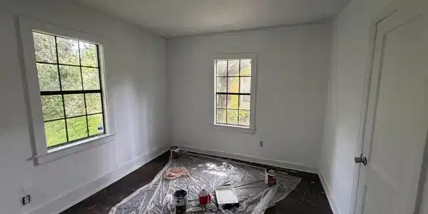 Image 3: Spacious room featuring white walls, dark wood-finish flooring, and multiple windows
