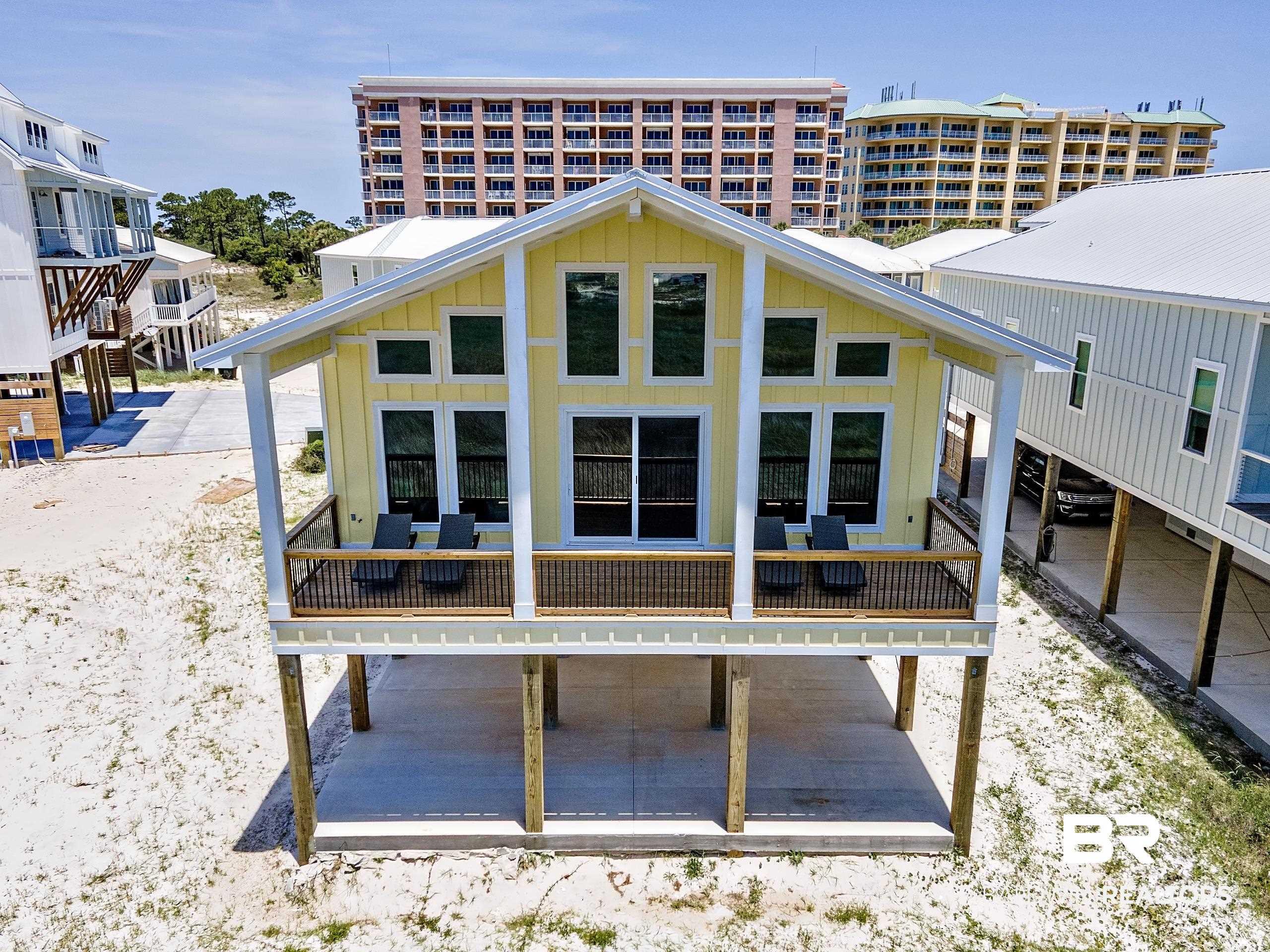 Image 3: Yellow exterior with white trim, featuring a covered front porch with dark railing
