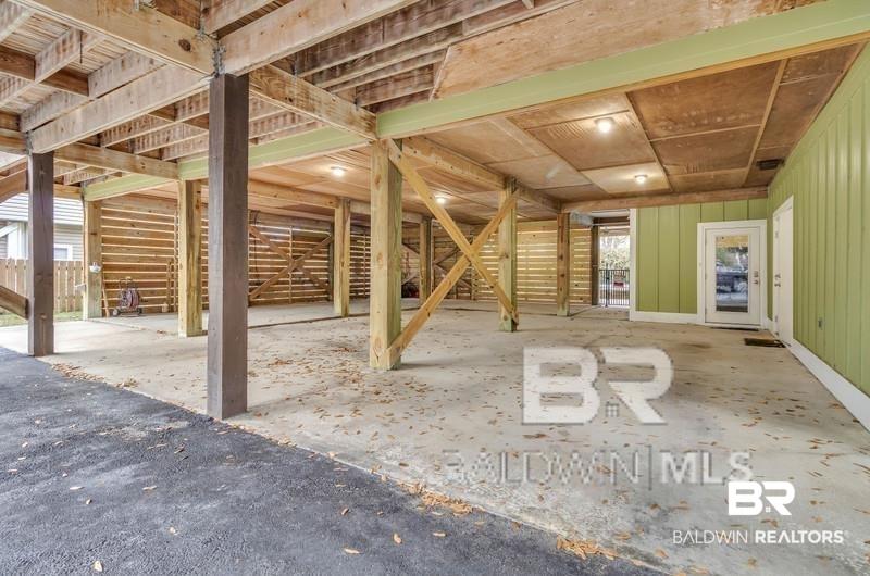 Image 3: Covered ground-level space with concrete flooring and exposed wooden structural beams